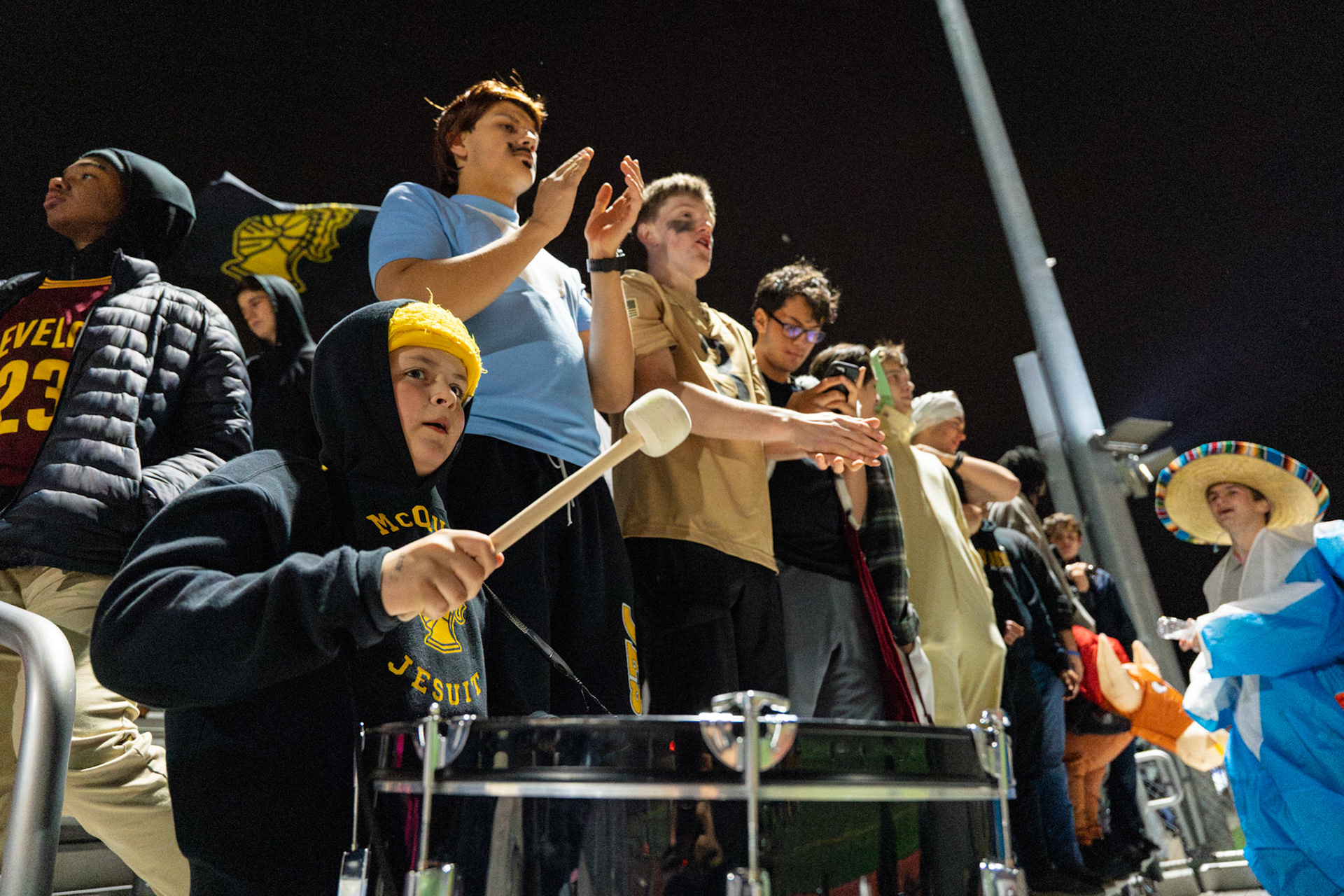 McQuaid Jesuit High School students sitting in the student section clap and beat a drum for their school’s game against Pittsford, Nov. 1, 2024, in Brighton, N.Y.