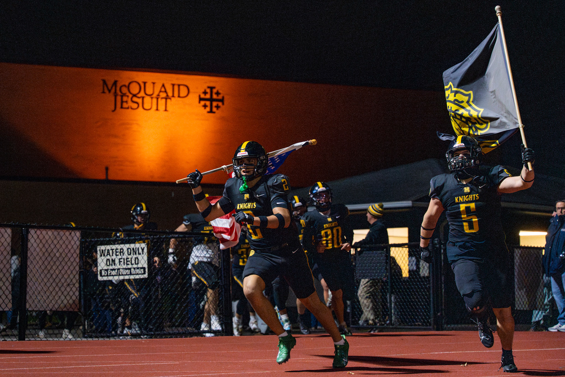 McQuaid Jesuit High School football players run onto the field for a sectional playoff game against Pittsford, Nov. 1, 2024, in Brighton, N.Y.