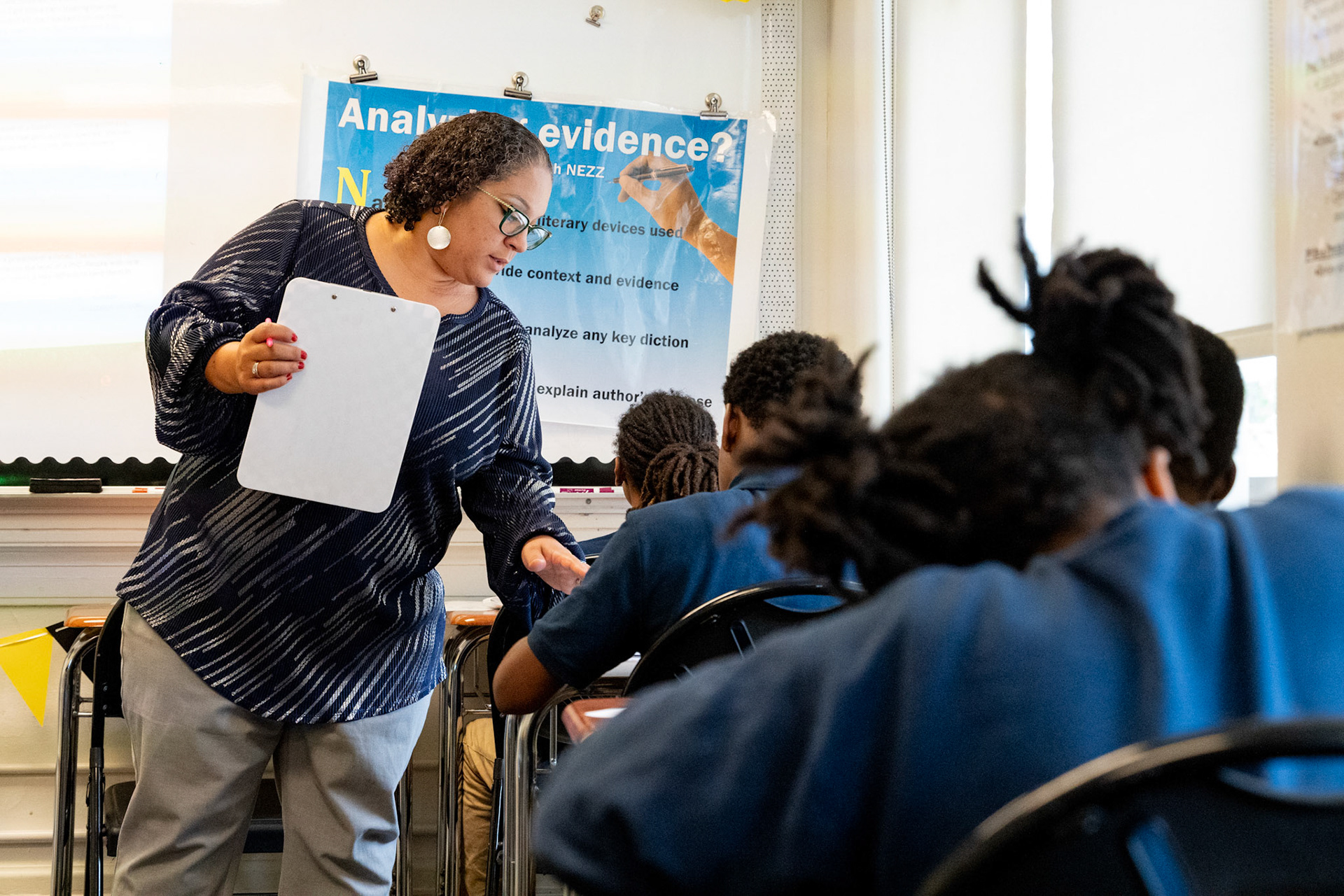 Amber Pollox-Quinn talks to one of her special education English language arts students, Sept. 25, 2024, on the campus of Uncommon Schools Rochester Prep Chili Campus Middle School in Rochester, N.Y.