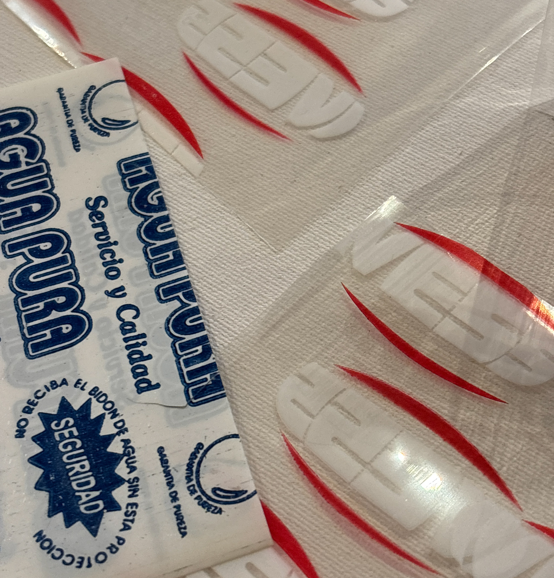 Precintos termocontraíbles de PVC impresos con logotipos y mensajes de seguridad, utilizados para el sellado de bidones y productos alimenticios.