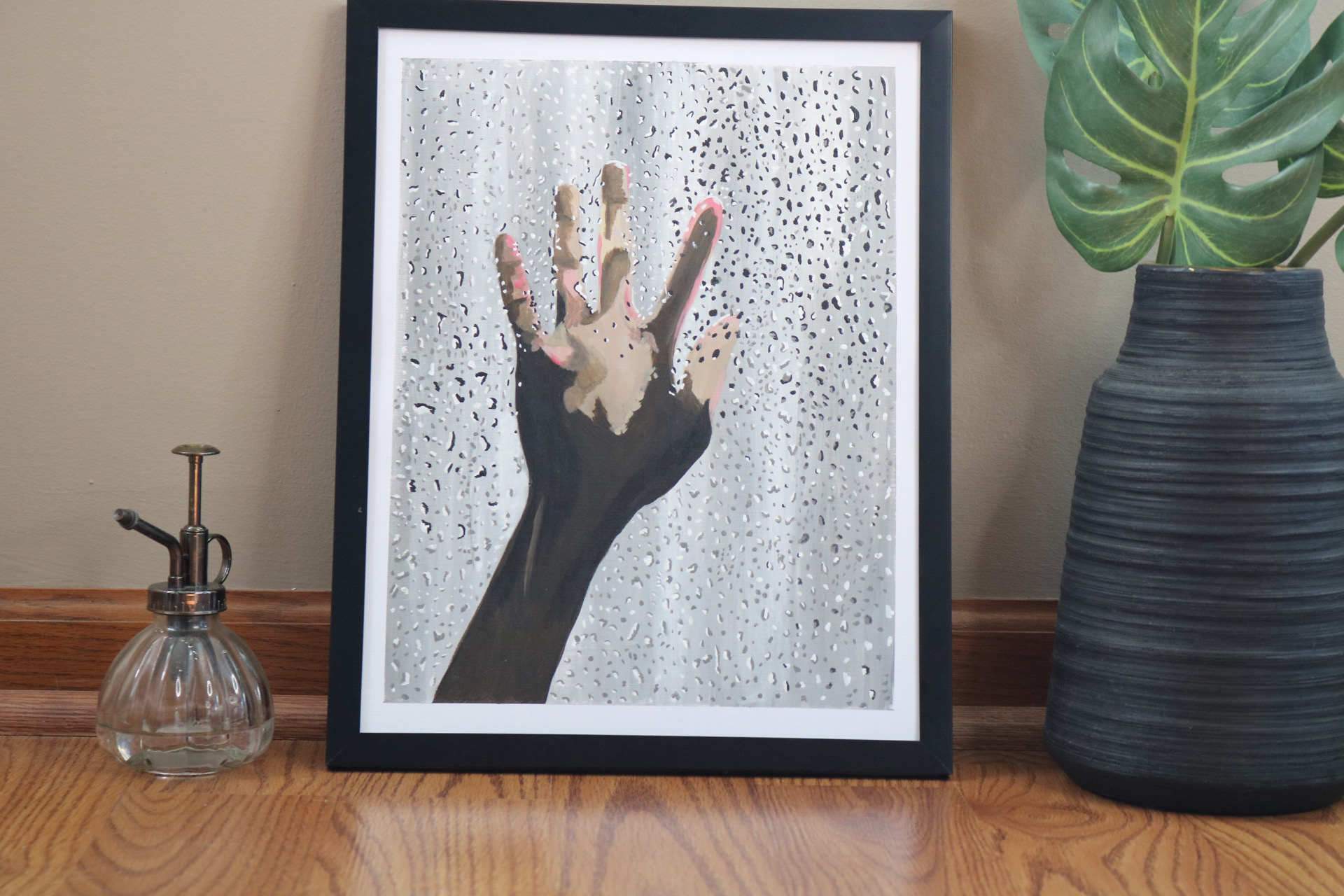 Hand on rainy window