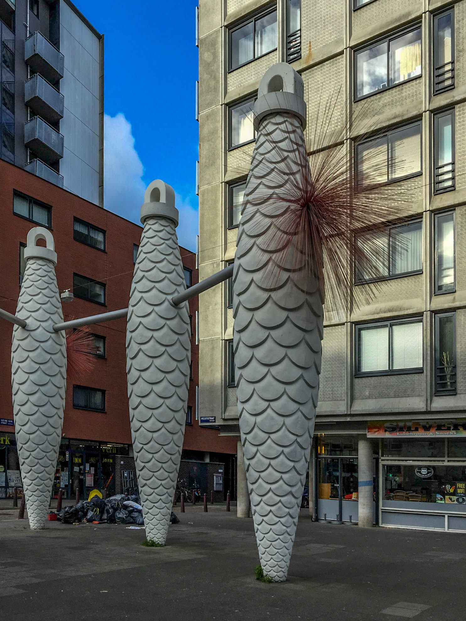 Fête galante aan de Weesperstraat (Centrum) bijgenaamd 'Denneappels met schaamhaar': viertal betonnen koekoeksklokgewichten in de vorm van sparappels met uitstulpingen in glasfiber