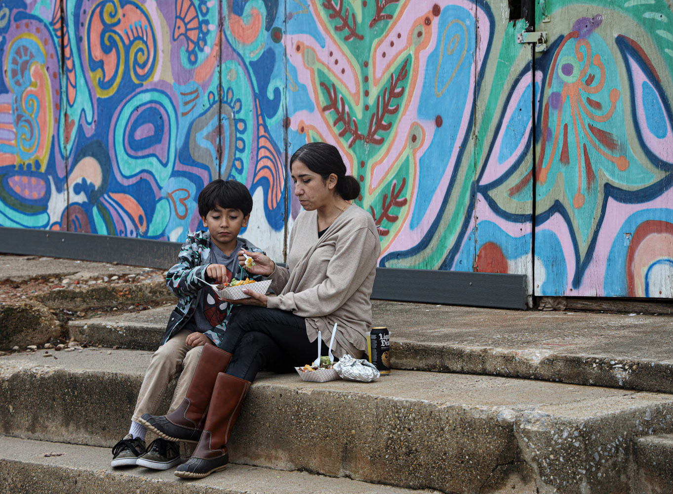 A woman and her son share a quiet moment over a meal during the 2023 Día de los Muertos Festival.