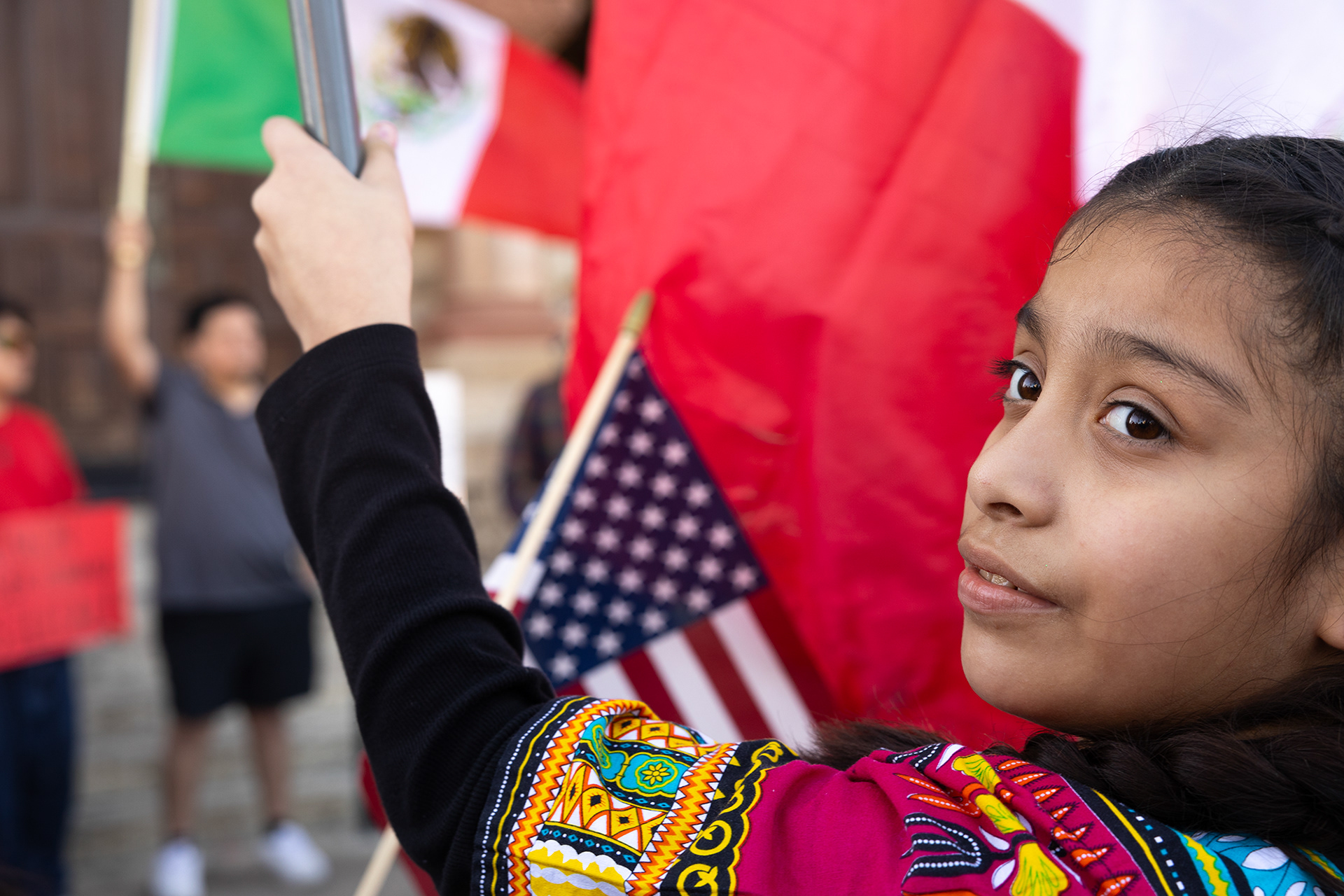 A young child protests against ICE and mass deportations happening around the country alongside her father and brother in Denton's Historic Downtown square on Feb. 1. Photo by Maria Vargas