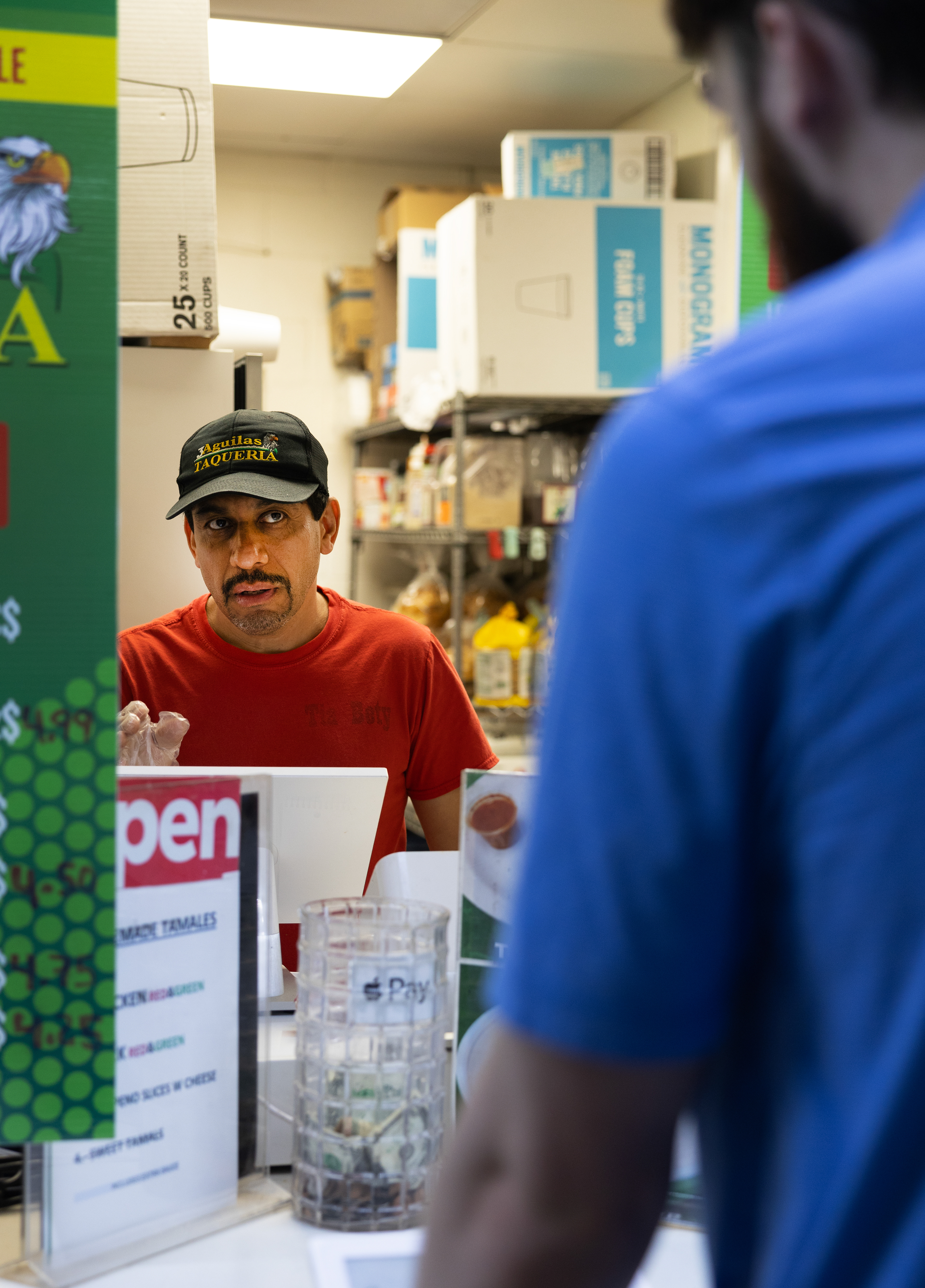 Ramón Maganda takes the order of the gas station attendant that works in the same space as him. He and his wife Bety hope to open their own storefront someday.