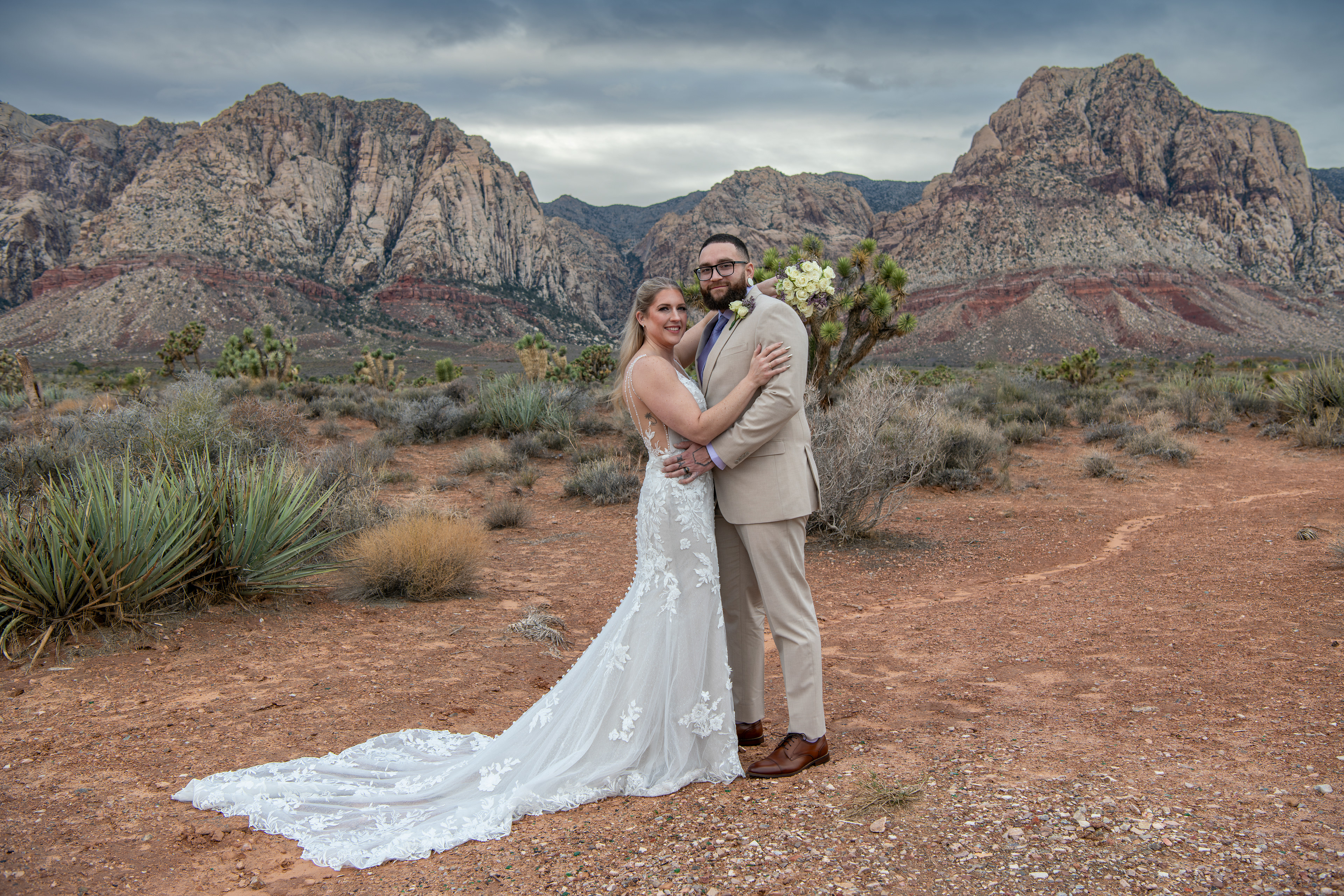 Wide wedding portrait of the newlyweds surrounded by the Mojave Desert landscape near Bonnie Springs and Red Rock.