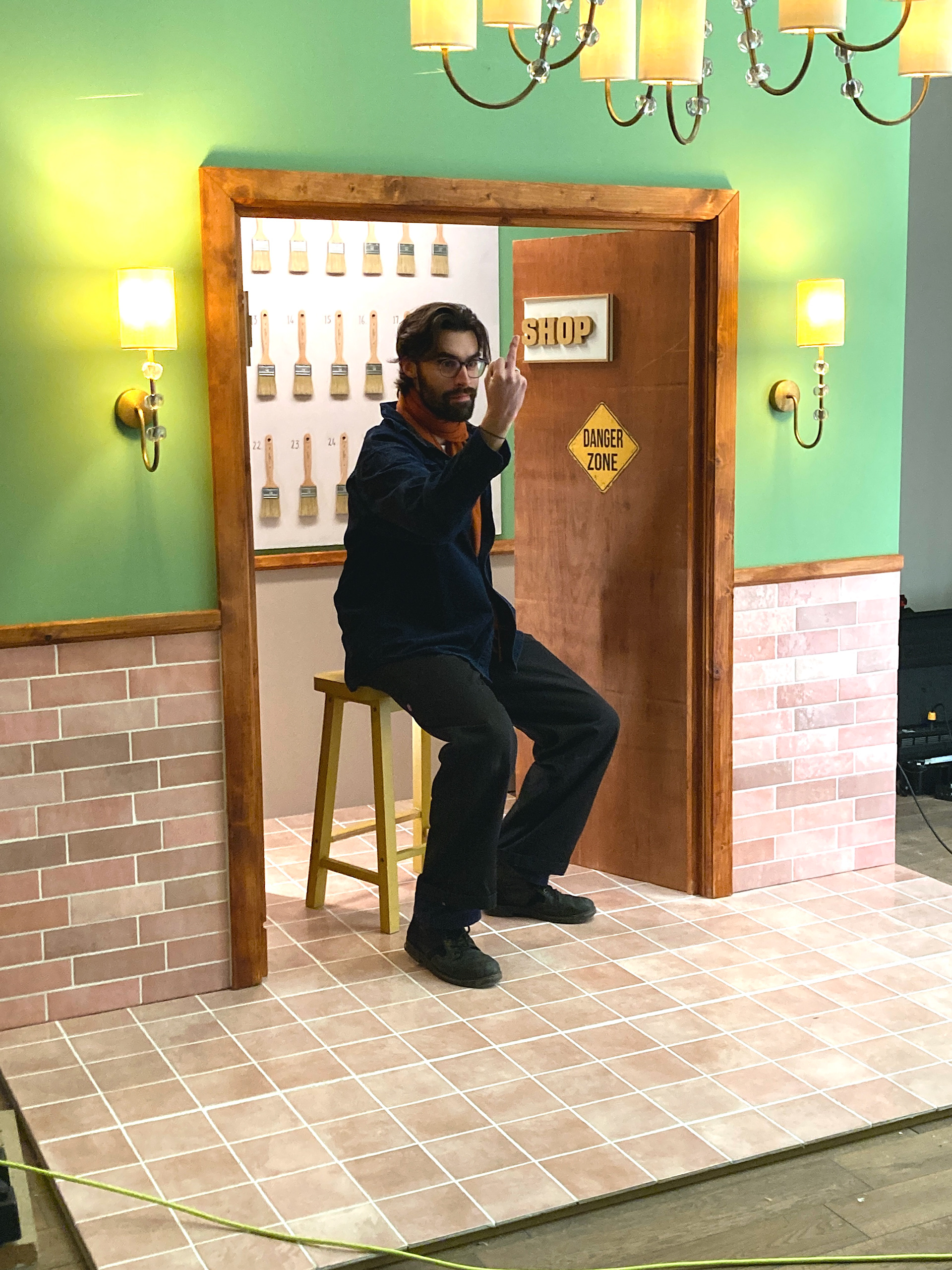 Photographer Laurence Hills, goofs around on set for the Spring 23 Collection, inspired by Wez Anderson.
