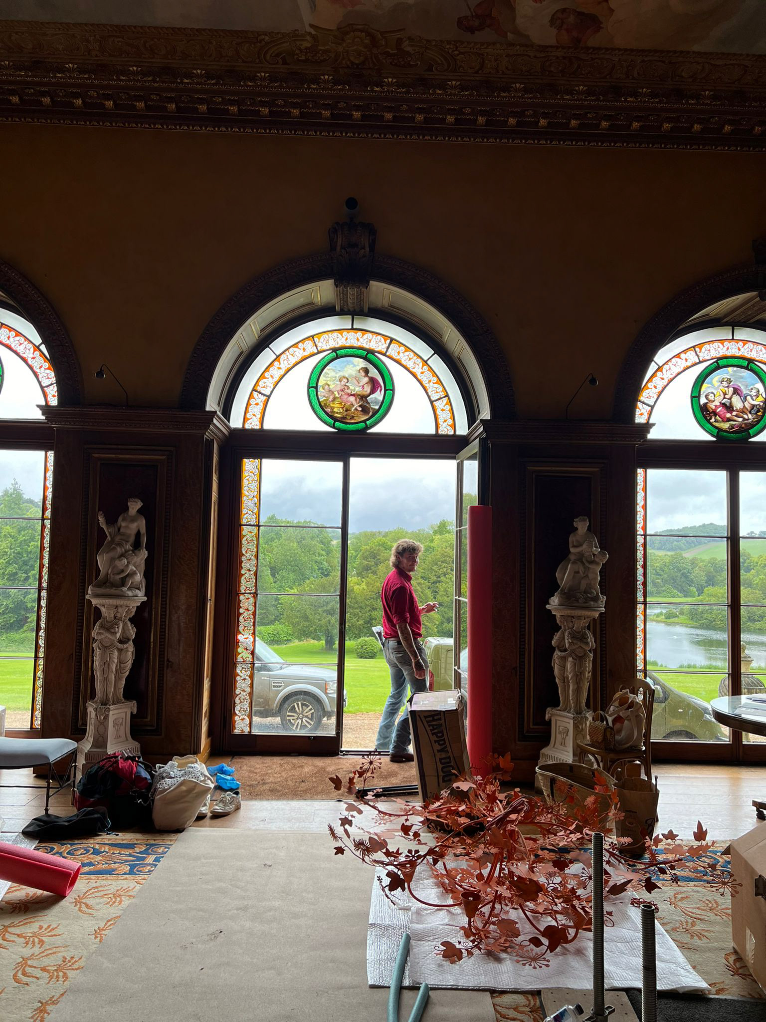 A crew member helps unpack product on set at West Wycombe Park, for the Autumn 24 Collection.