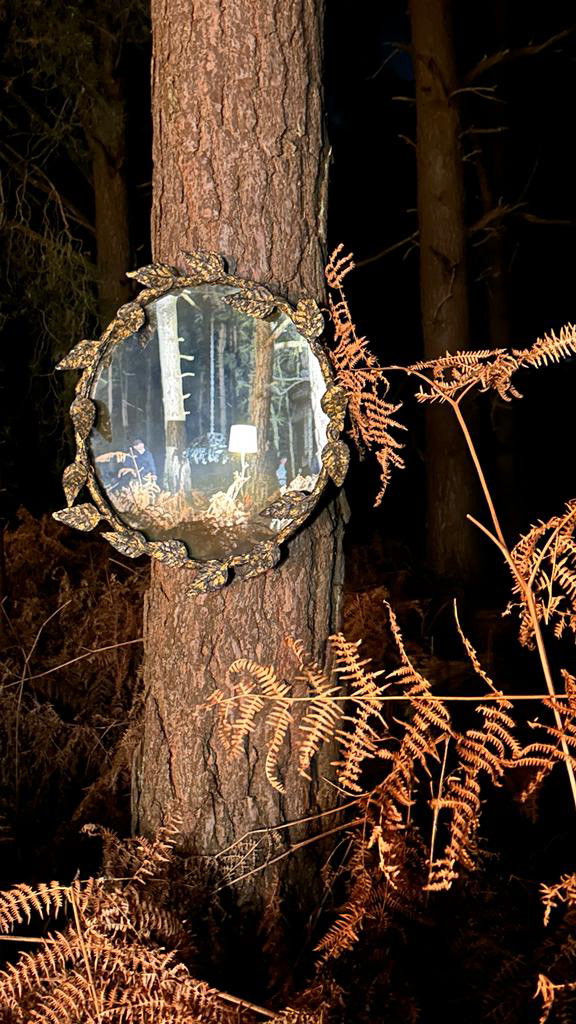 A mirror hangs on a tree, behind the scenes at the Porta Romana 35th anniversary film.