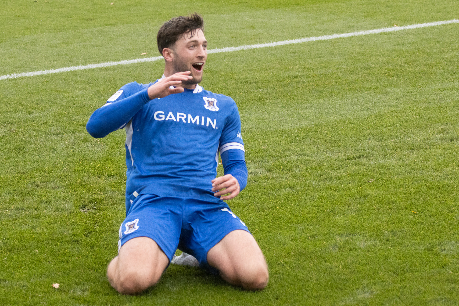 Christie Ward kneeslides in celebration of his goal.