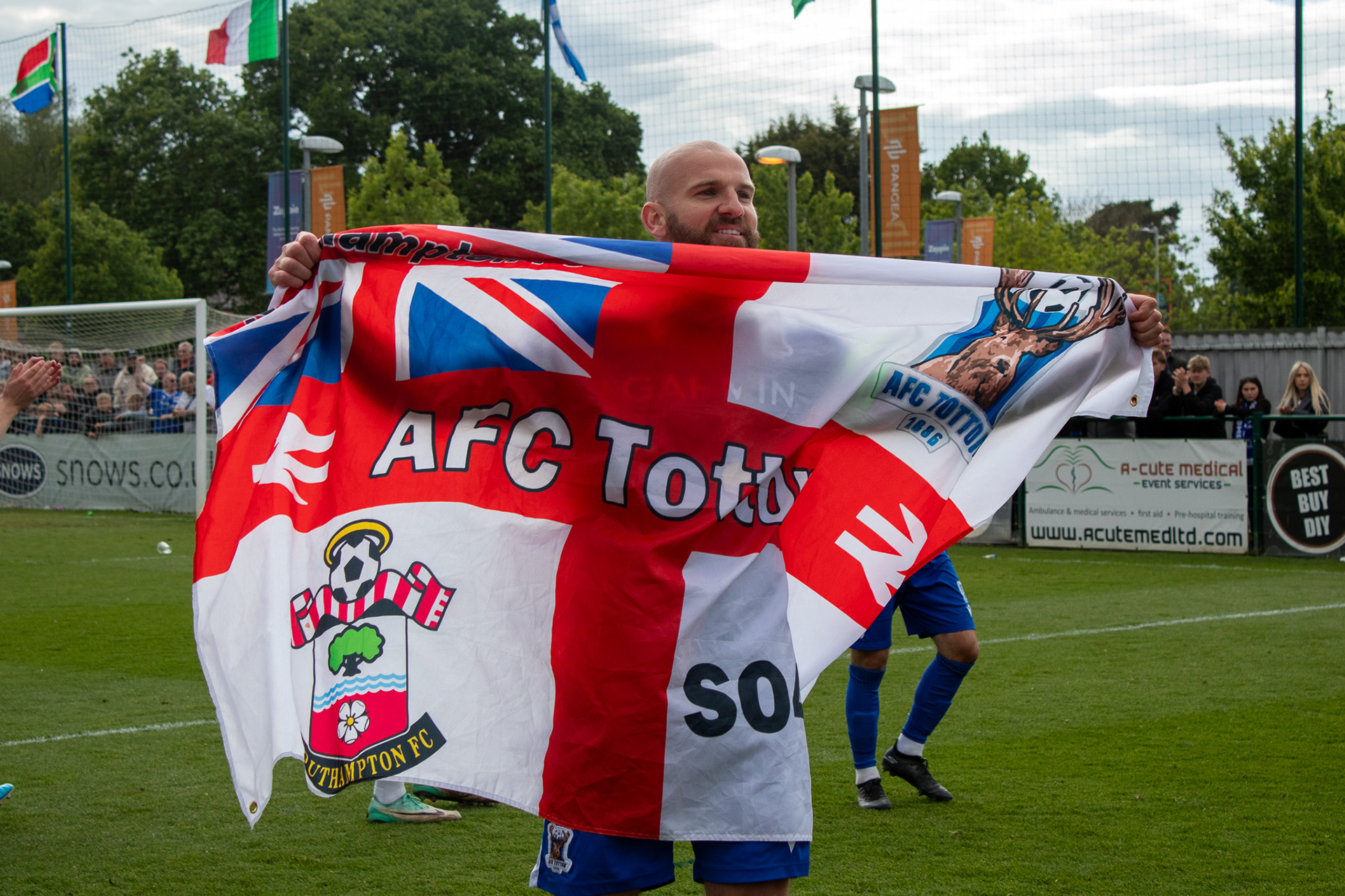 Mike Carter holds an AFC Totton England flag.