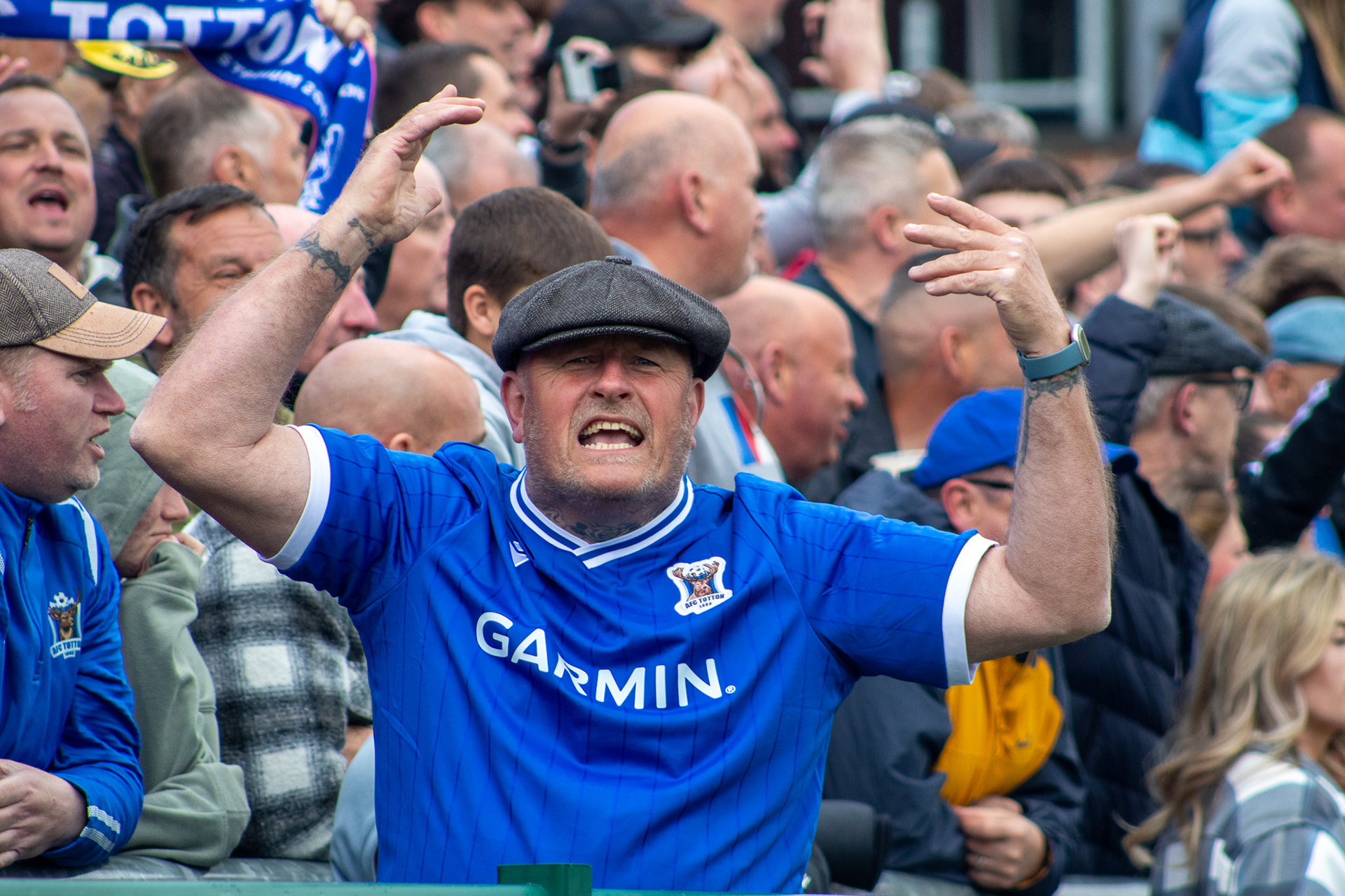 A fan builds atmosphere within the crowd.