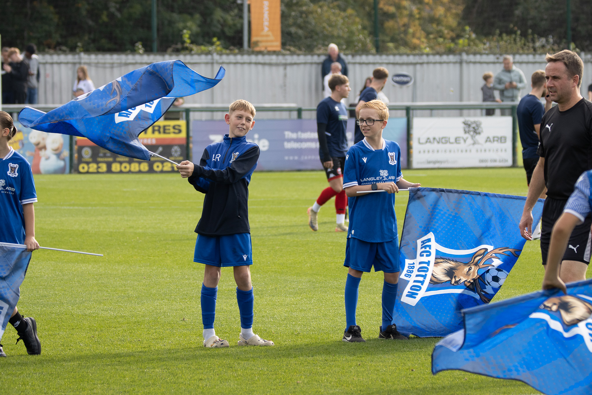 Young fans of AFC Totton wave flags ahead of the FA Cup fixture.