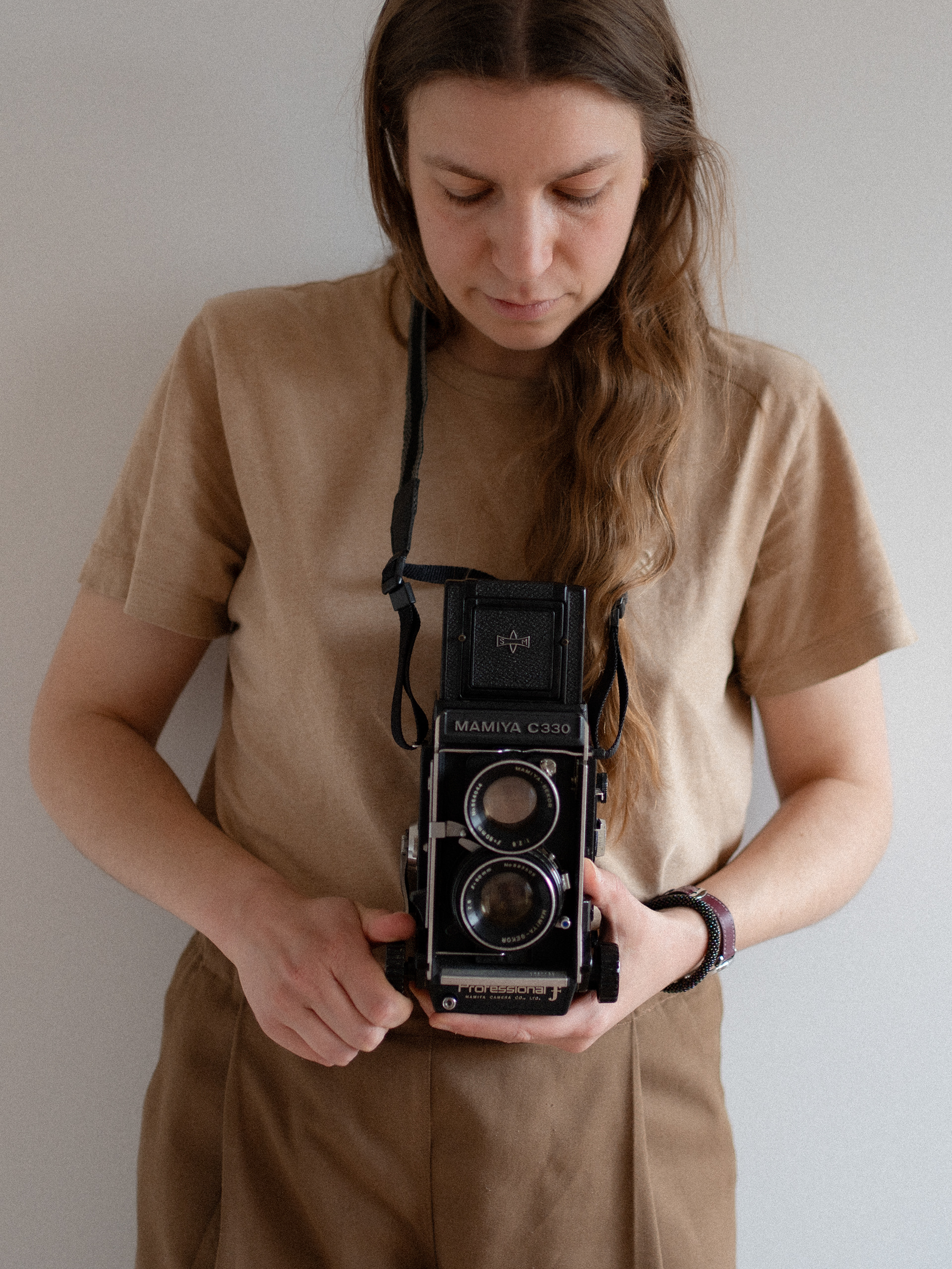 Une photographe regarde dans le viseur d'un appareil photo argentique moyen format