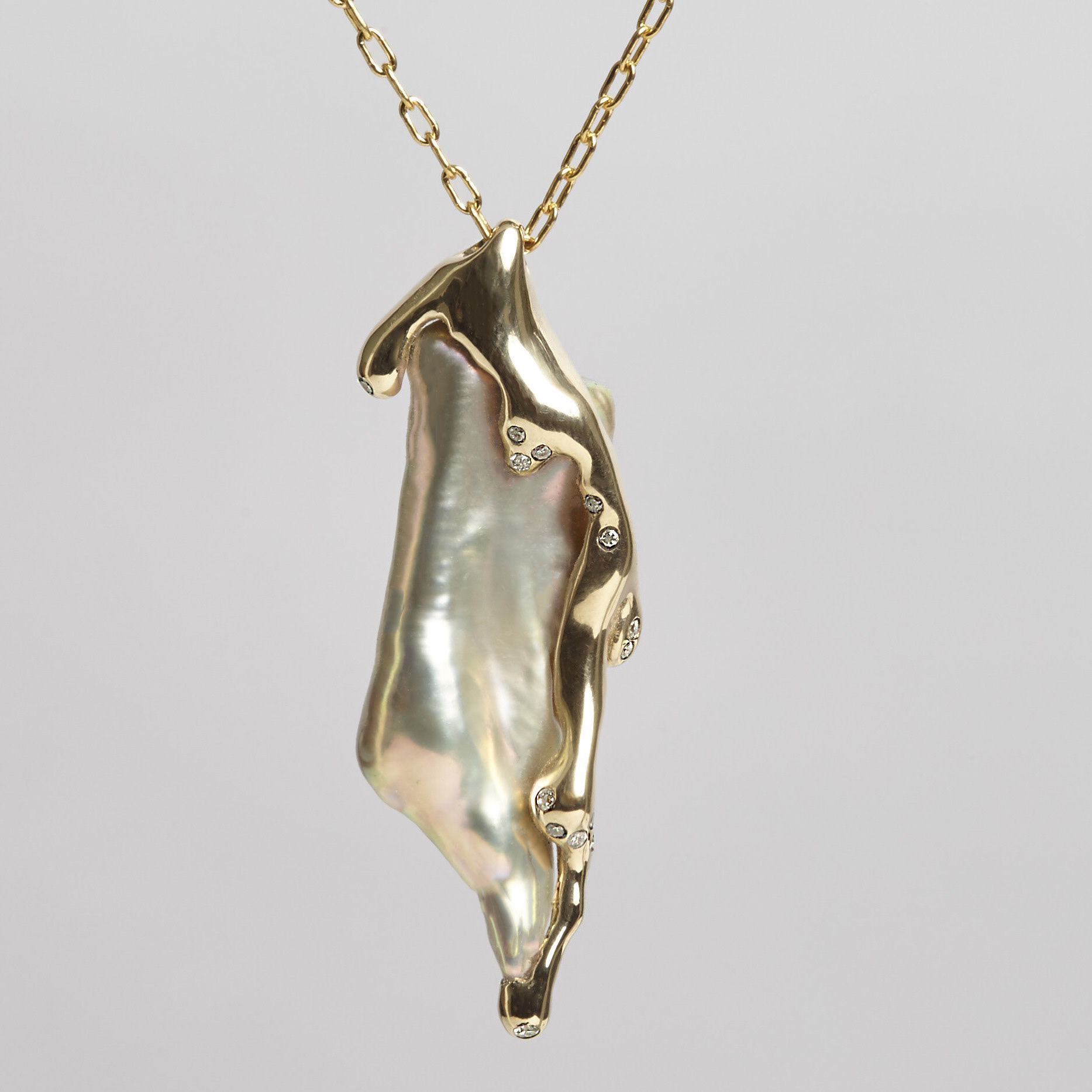 Molten 14k gold holds twenty one diamonds in place and sorounds an organic Japaniese freshwater pearl. 