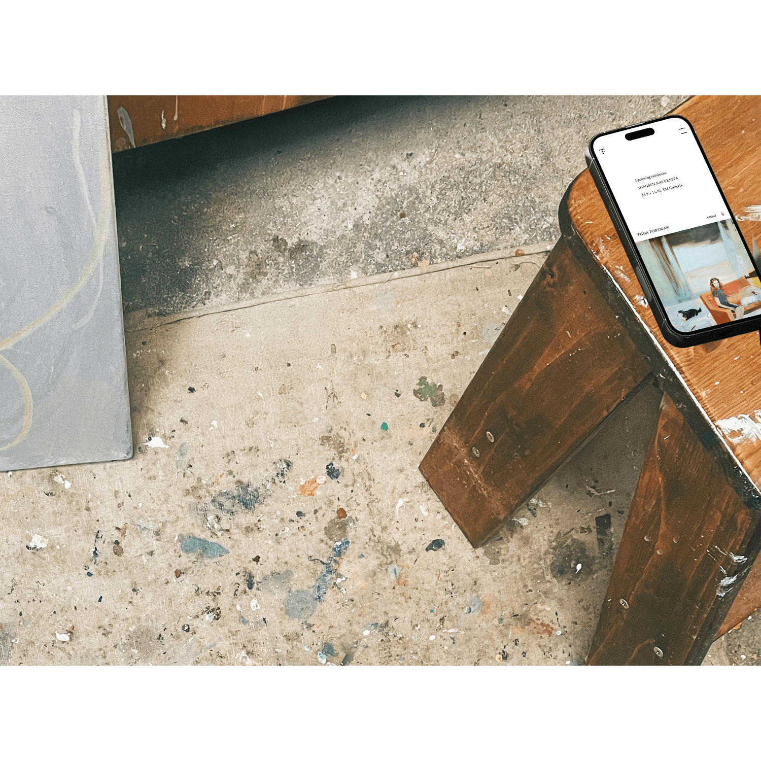 A mobile phone on a stool showing a website for a visual artist