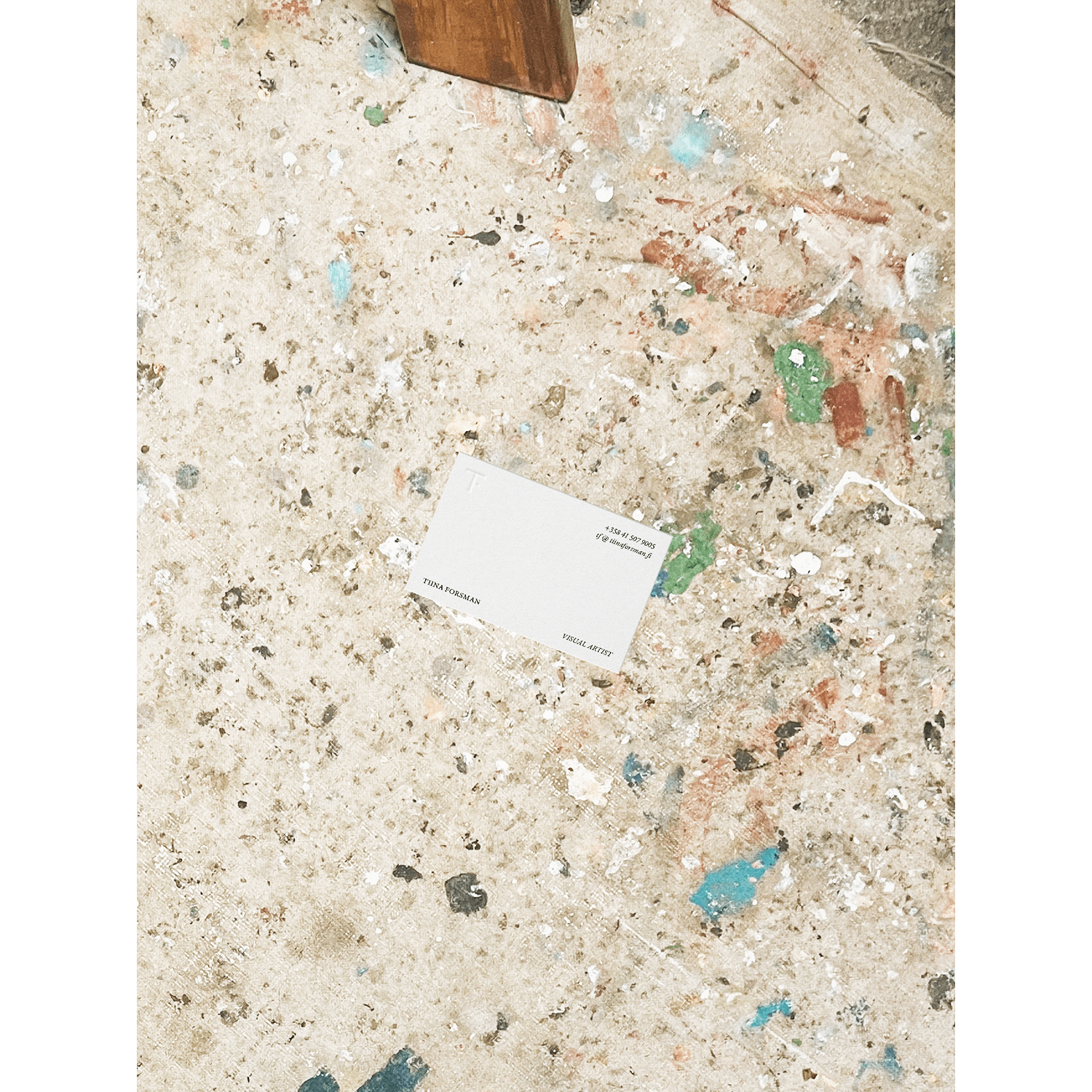 A business card on atelier floor for a visual artist