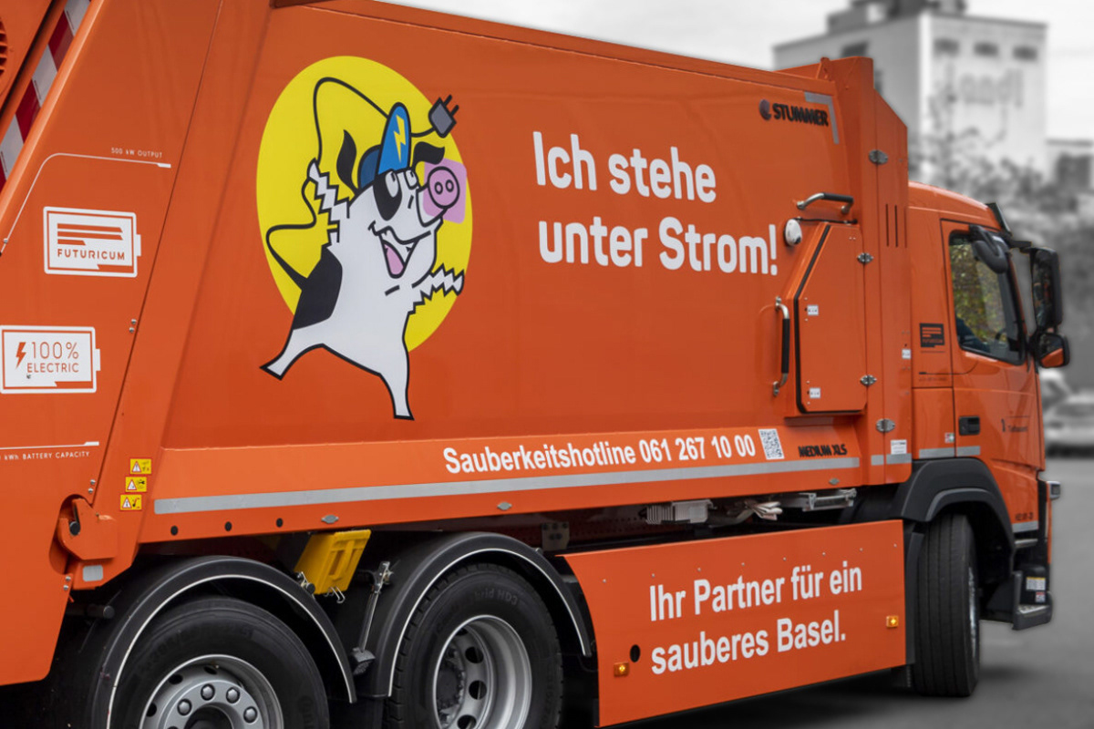 Oranges Elektro-Kehrfahrzeug des Tiefbauamts Basel mit bedruckter Schweinehund-Grafik