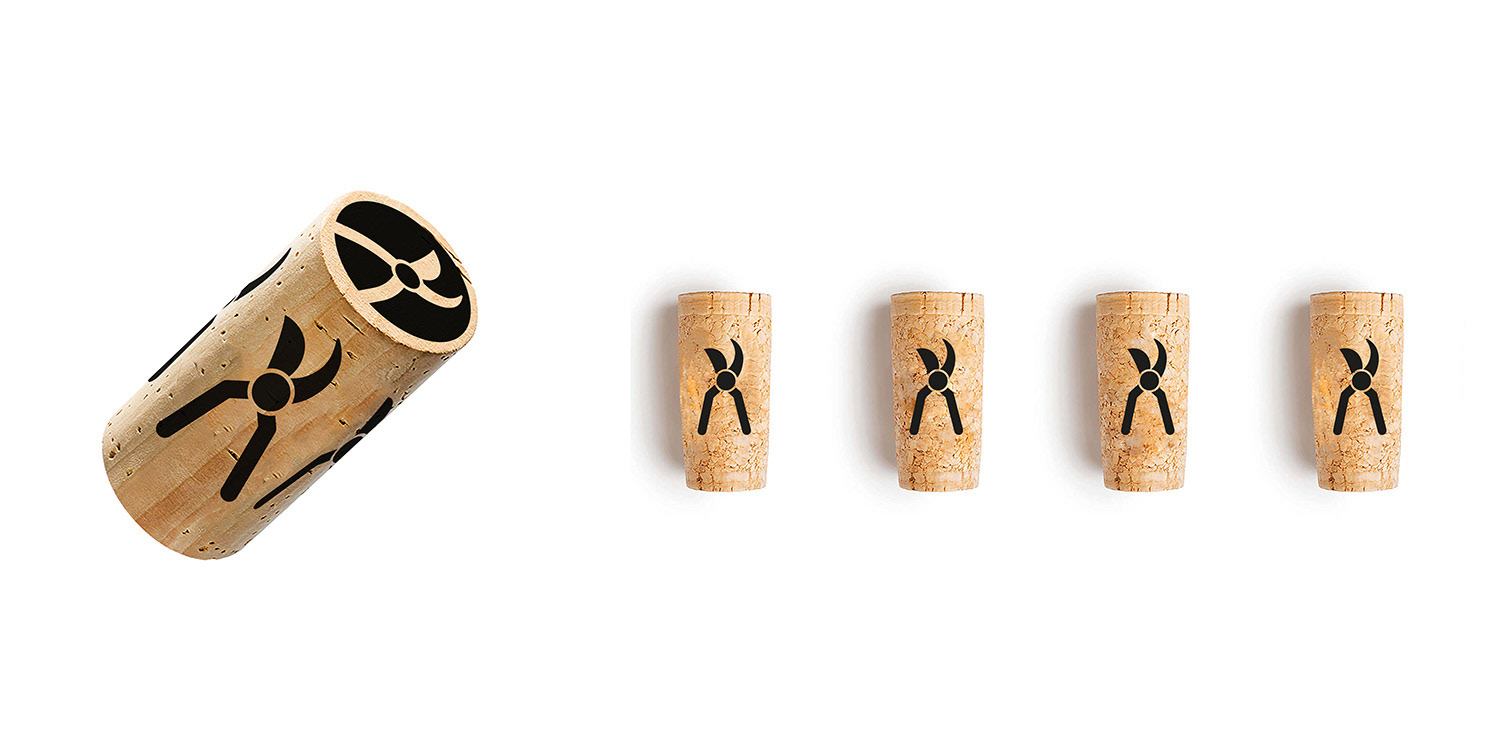 Fünf Weinkorken aus Kork mit eingebranntem Rebschere-Symbol der Marke Les Quatres Vignerons