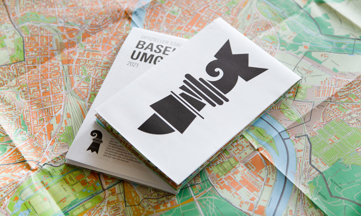 Gefalteter Stadtplan Basel mit neu angeordnetem Baslerstab-Icon auf ausgetreckter Stadtkarte – Grafikdesign von Nils Bärfuss