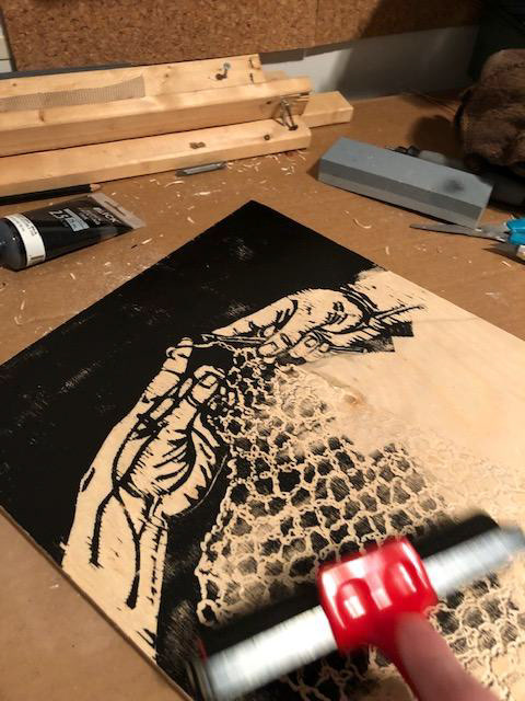 Revealing the full image by coating the woodblock in ink and pulling a test print.