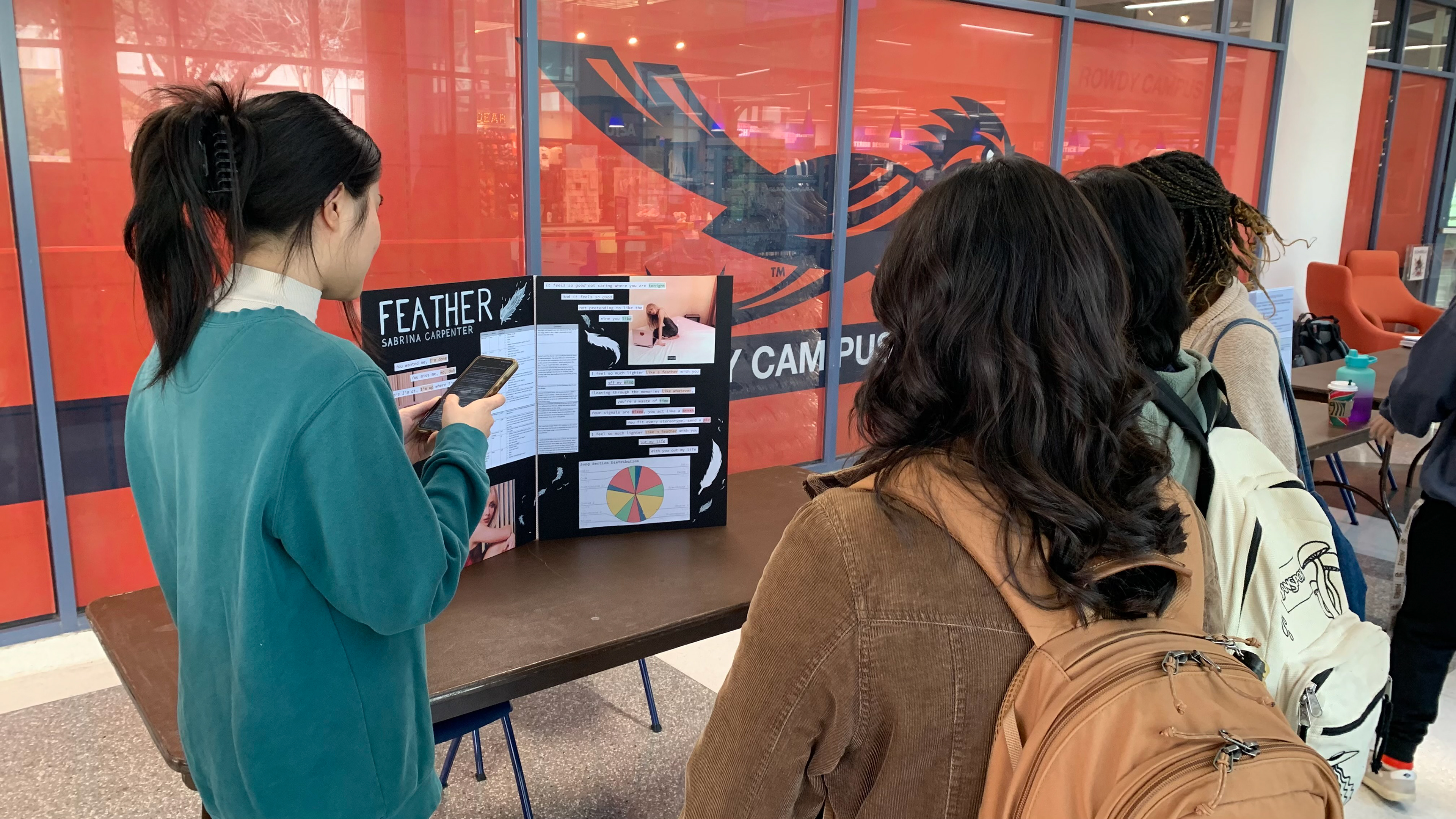 Jocelyn Ting presents on "Feather" by Sabrina Carpenter to audience members.