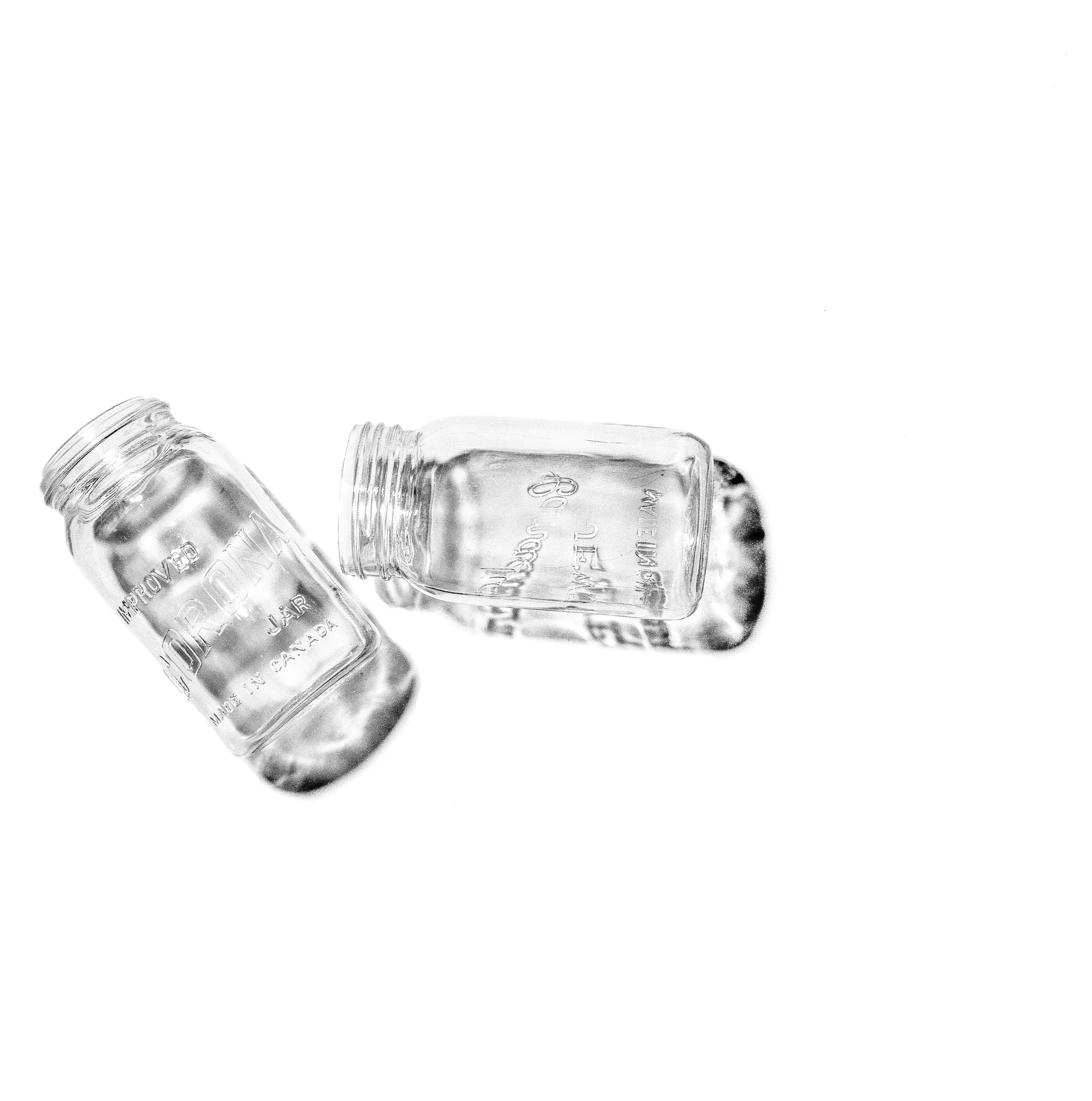 Sketch no. 1 Preserves Jars c. 1945 photograph - 120 film I was struck with this creative ideas last week so I was in the studio all weekend photographing & developing a mini-series of photographic 'sketches' that explore things I find interesting, have character & a bit of a story to them. Now, I am excited to share with you a 120 back & white film print of the 1st photograph in the series of 3. I may release the other two shortly. These jars came with my house - that was built in 1904 - & were found hidden & tucked away in my basement filled with various preserves & covered in calcium & rust buildup. I thought for sure their purity would be lost due to heavy stains & scoring/etching. Their design & artwork piqued my interest so I soaked them in double strength vinegar for a few hours & now they sparkle like new. There are minimal scratches & I was able to remove all the stains. The embossing on the bottom of one of the jars reads, 1945. The newspaper they were found sitting on were from the same era. They now sit beautifully, for this photograph, deconstructing the mythos of country living. I am particularly drawn to the font used for Corona & the cursive font in Canadian JEWEL. Design on glass is just cool. Please note the dark edges are subtle shadows that ground the subject on a surface. This gives the print detail & texture.