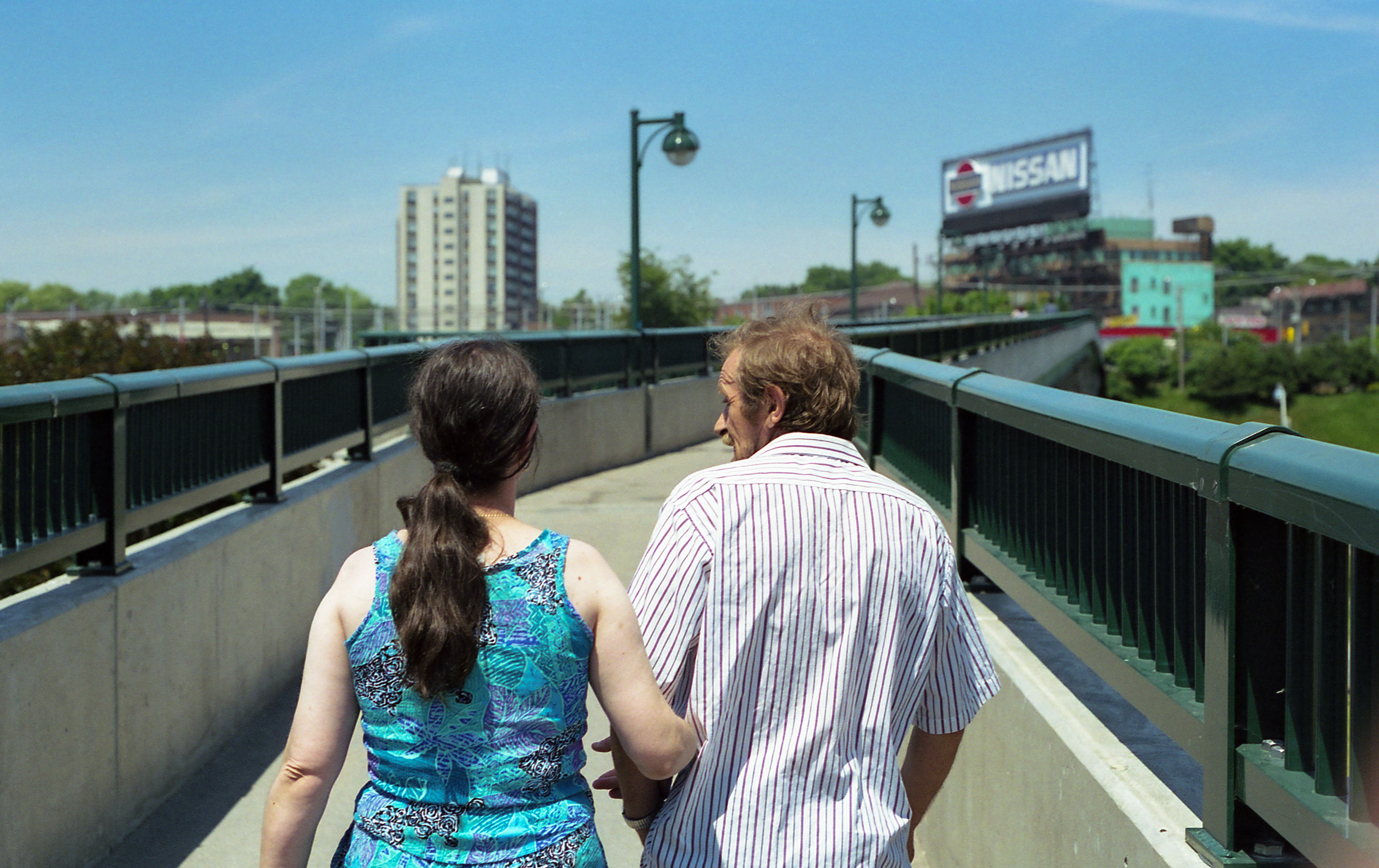 Together on the Roncesvalles Pedestrian Bridge, Toronto, Ontario (1997) no. 1 - 135 film // This colour film photograph was taken in Toronto, Ontario along the Roncesvalles Pedestrian Bridge in 1997. This endearing couple was walking so closely together, speaking to each other lovingly that I wanted to capture their moment. I love looking back on these details & wonder where they are today & if they are as happy as they were in this moment together.