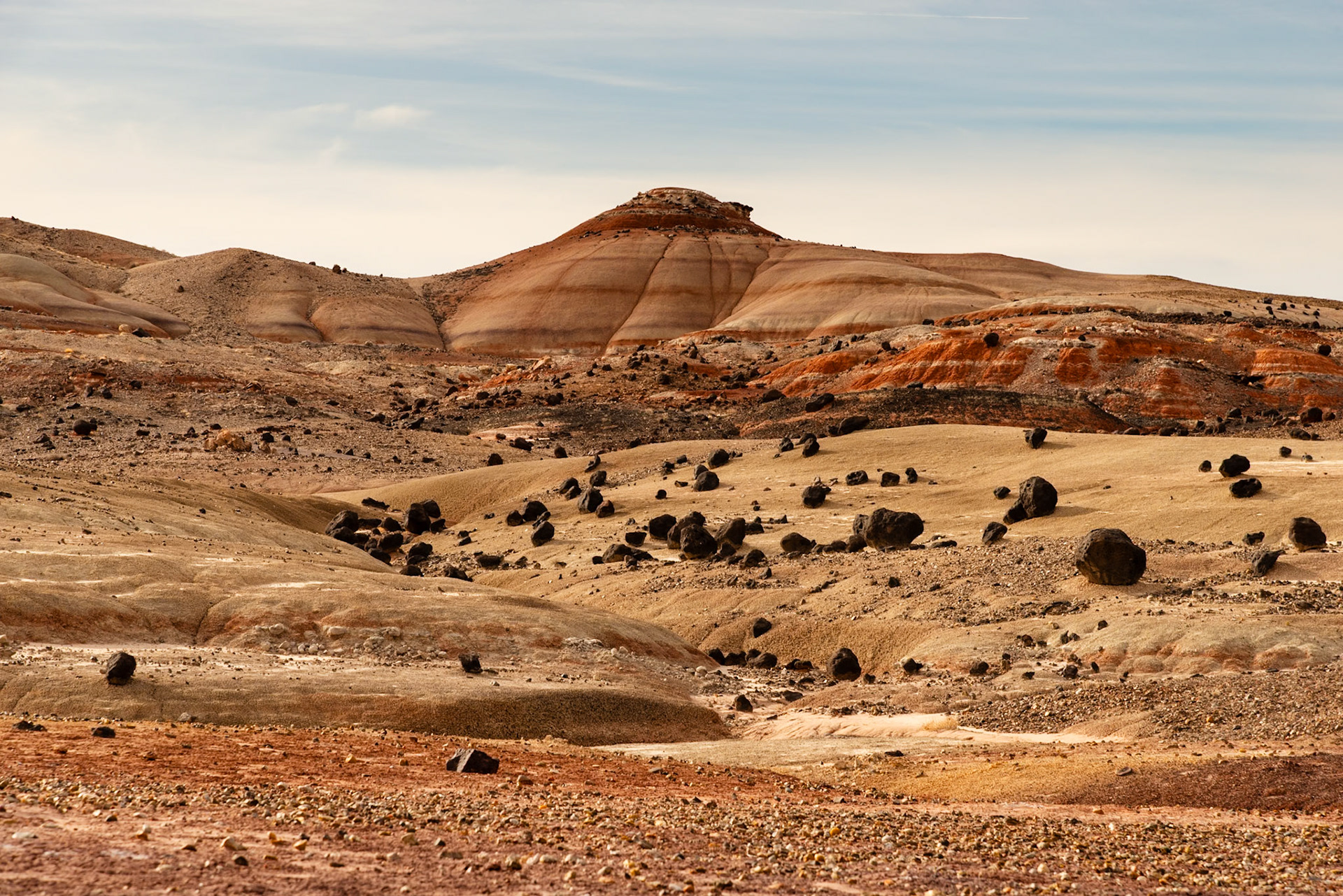 I love the contrast between the colorful Bentonite Hills and the dark volcanic boulders strewn about.