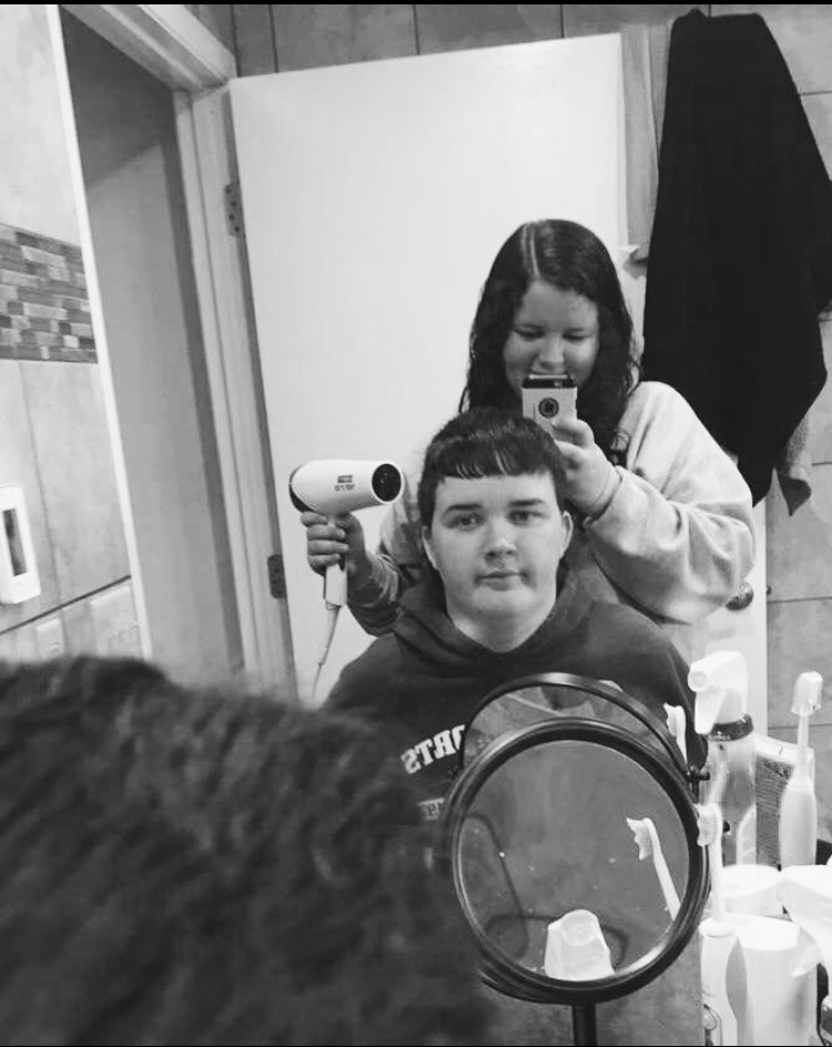 Johren and George in the bathroom in their childhood home in 2016. Johren is styling George's hair and he doesn't look too happy about it.