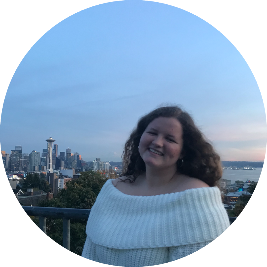 Johren Carpenter standing at Kerry Park in front of the Seattle skyline at sunset. 
