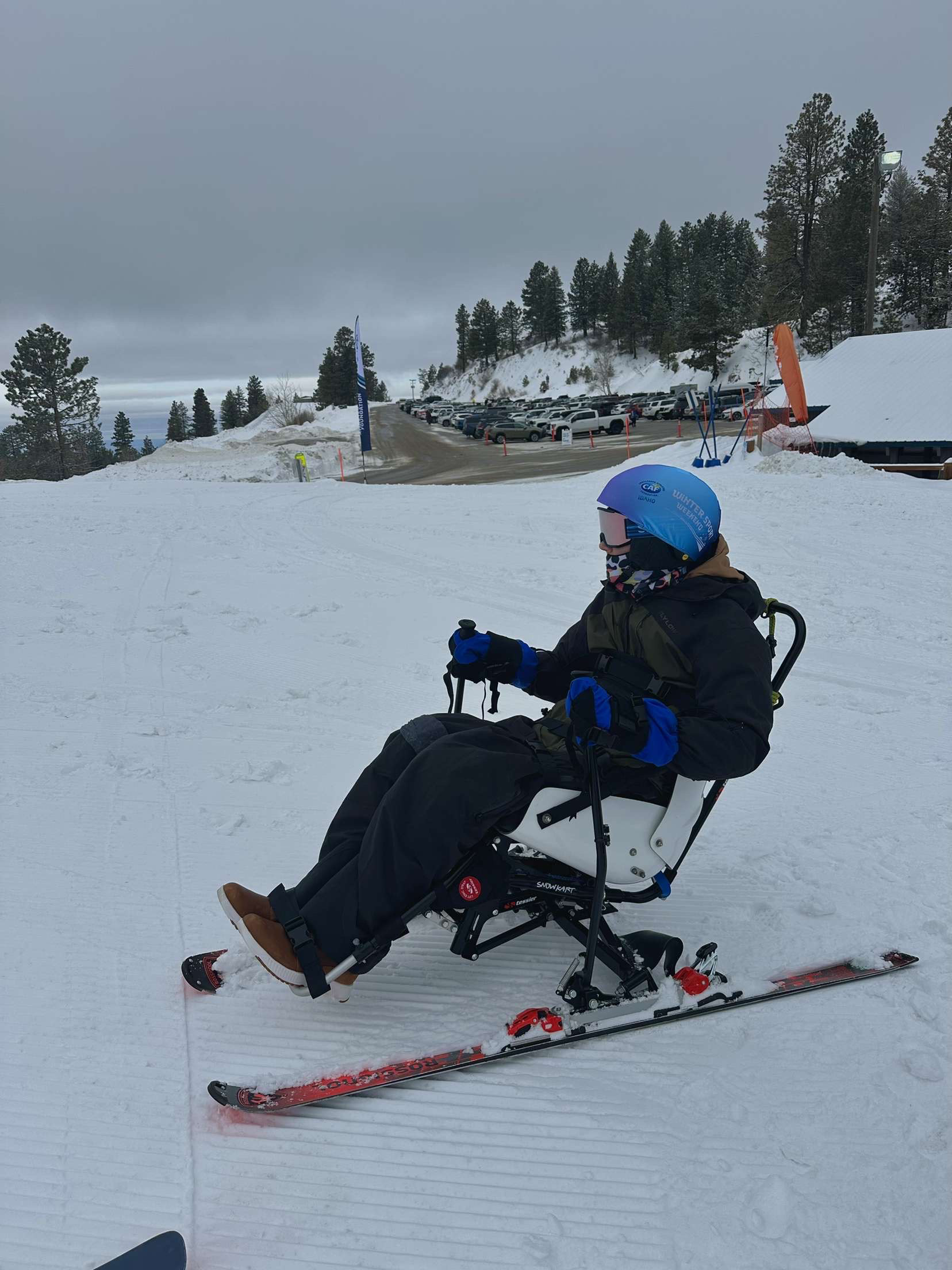 George Carpenter in a sit ski, a type of adaptive skiing equipment designed for individuals with limited mobility in their legs.