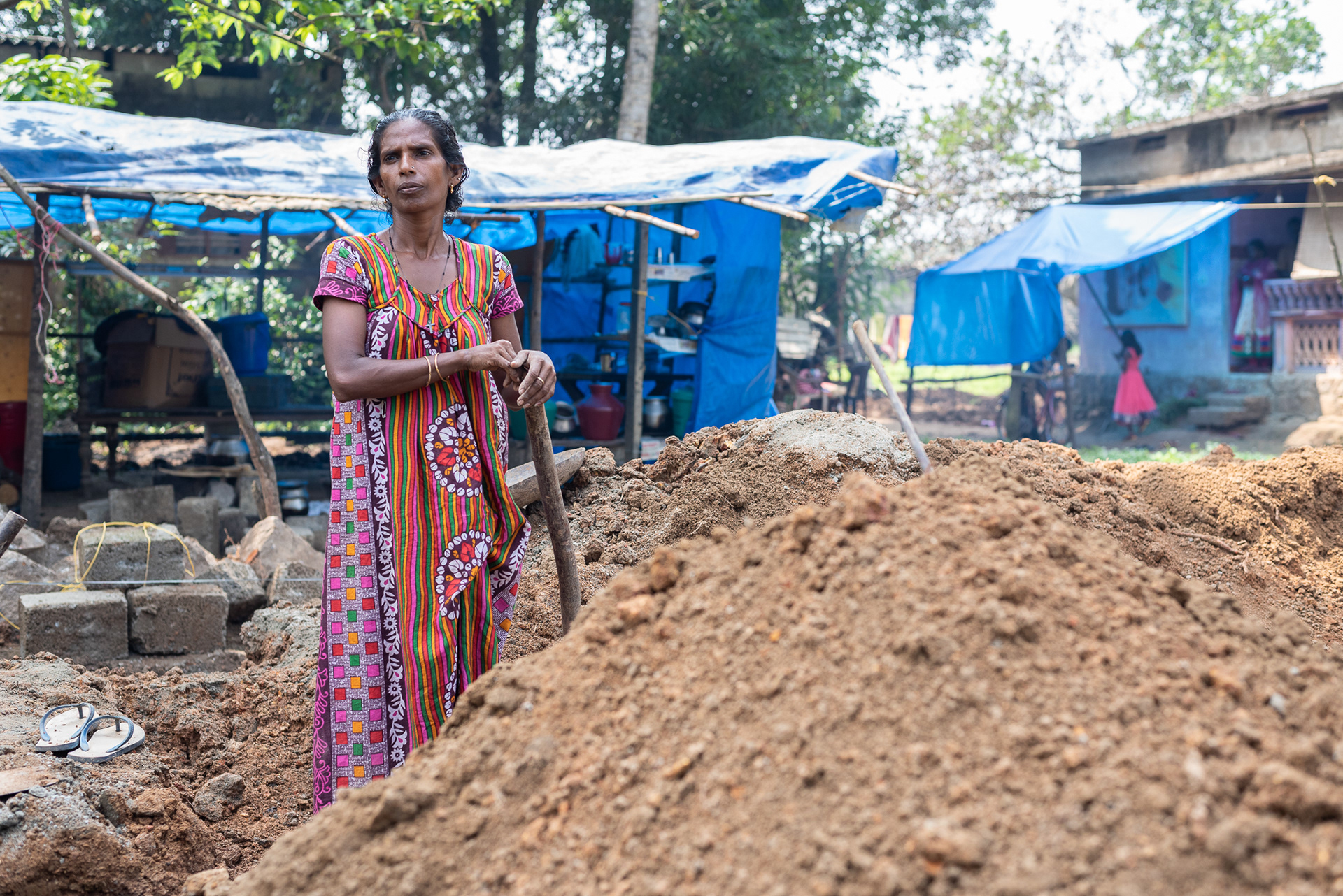 Subha T. D. stands among the dirt excavated for the foundation of her new home in Kurichimuttom, the largest Dalit colony in Kerala, India. Her previous home was destroyed in the August 14-18, 2018 flooding that brought 3-5 meters (10-15 feet) of rushing water. 