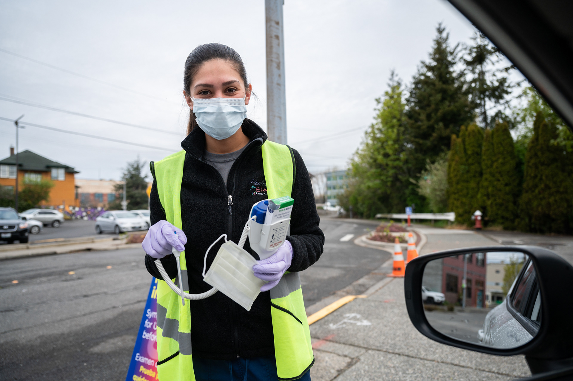 Curb-side screeners at Unity Care NW in Bellingham, Washington question patients and visitors about COVID-19 symptoms and potential exposure, conduct a temperature check, and issue a face mask prior to entry to the facility.
