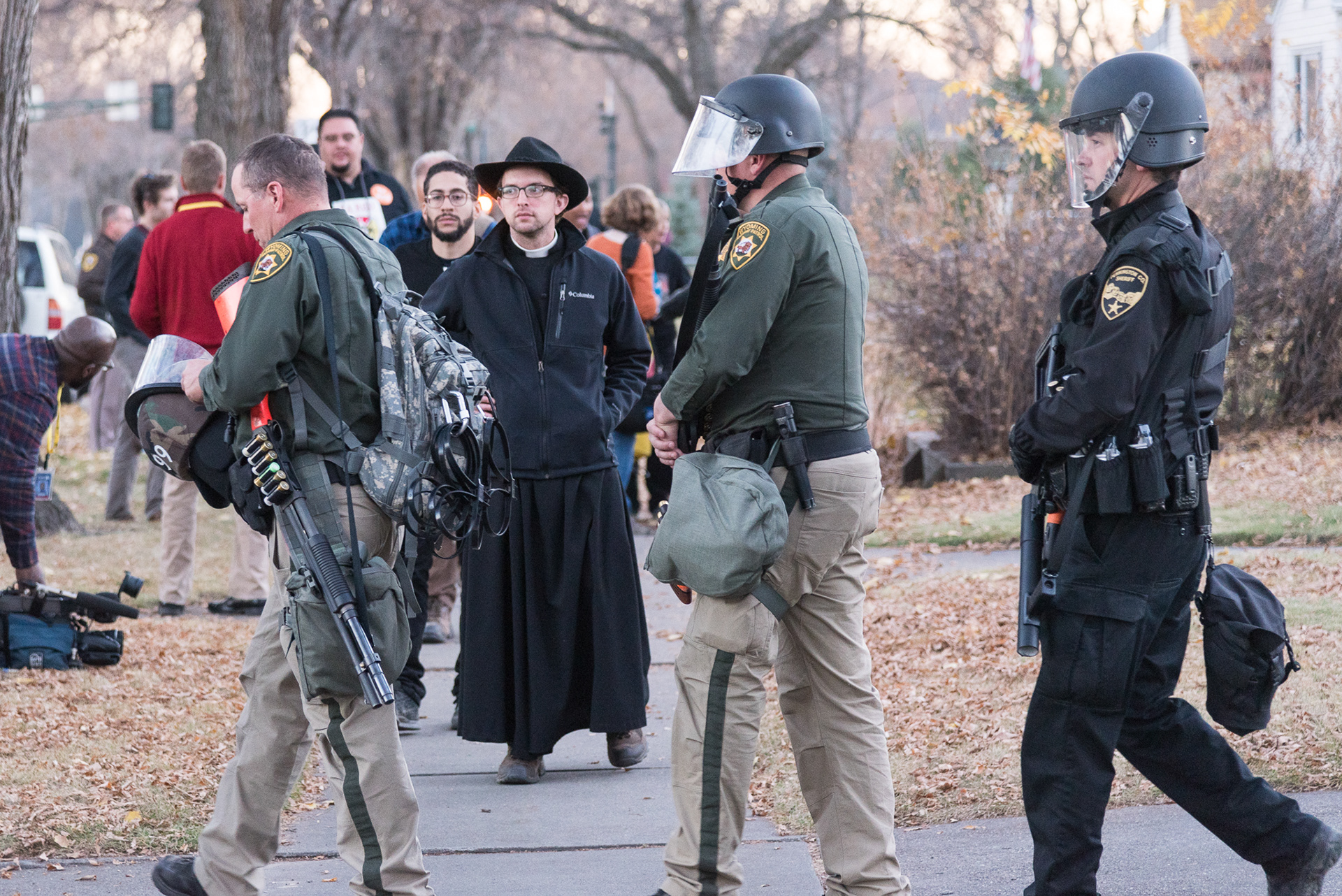 Father James Joiner of Portland, Oregon prepares to walk past riot police deployed to halt clergy protesting the Dakota Access Pipeline at the North Dakota governor's residence.