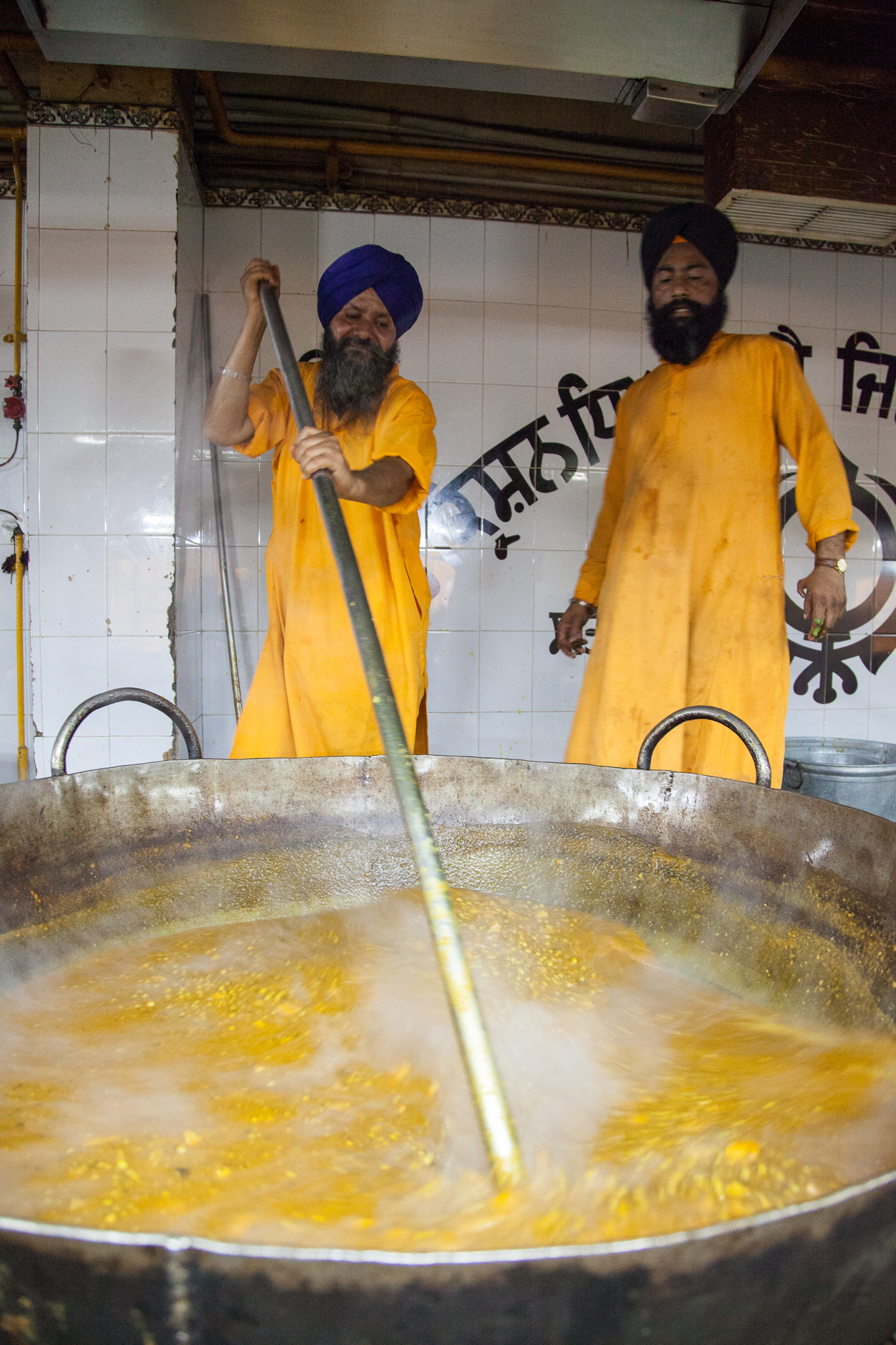 Workers prepare curried chick-peas at the Sikh Temple in New Delhi. They offer a free meal to 15,000 people - two times each day. Volunteers prepare and serve the meal which is supported by donations to the temple.