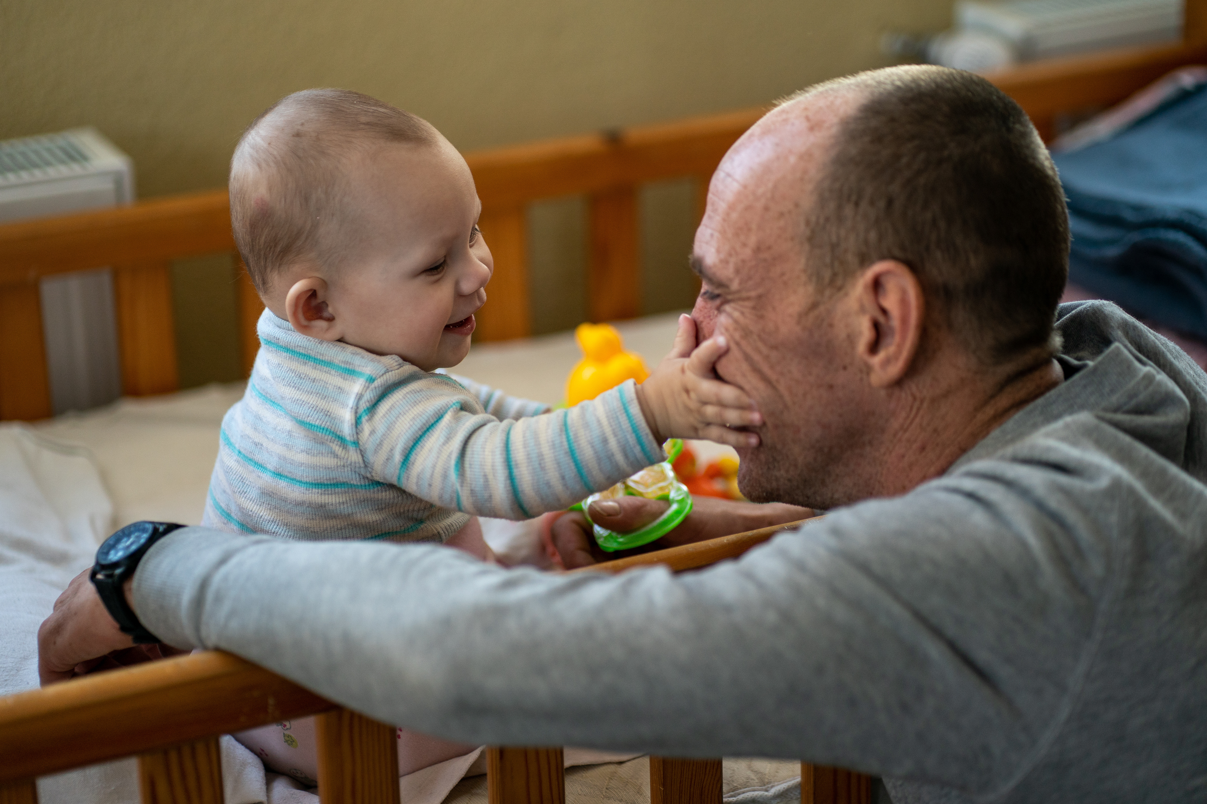 Alexander Tomchuk plays with his eight-month-old son at a center for Internally Displaced Persons (IDPs) in Fastiv, Ukraine, following the Russian invasion and bombardment their home in Kherson. Alexander is on a weekend visit and must return to his work in the contested city of Zaporizhia. His wife Anastasia fled to Poland when the fighting began in February 2022 and their son was born in Poland.