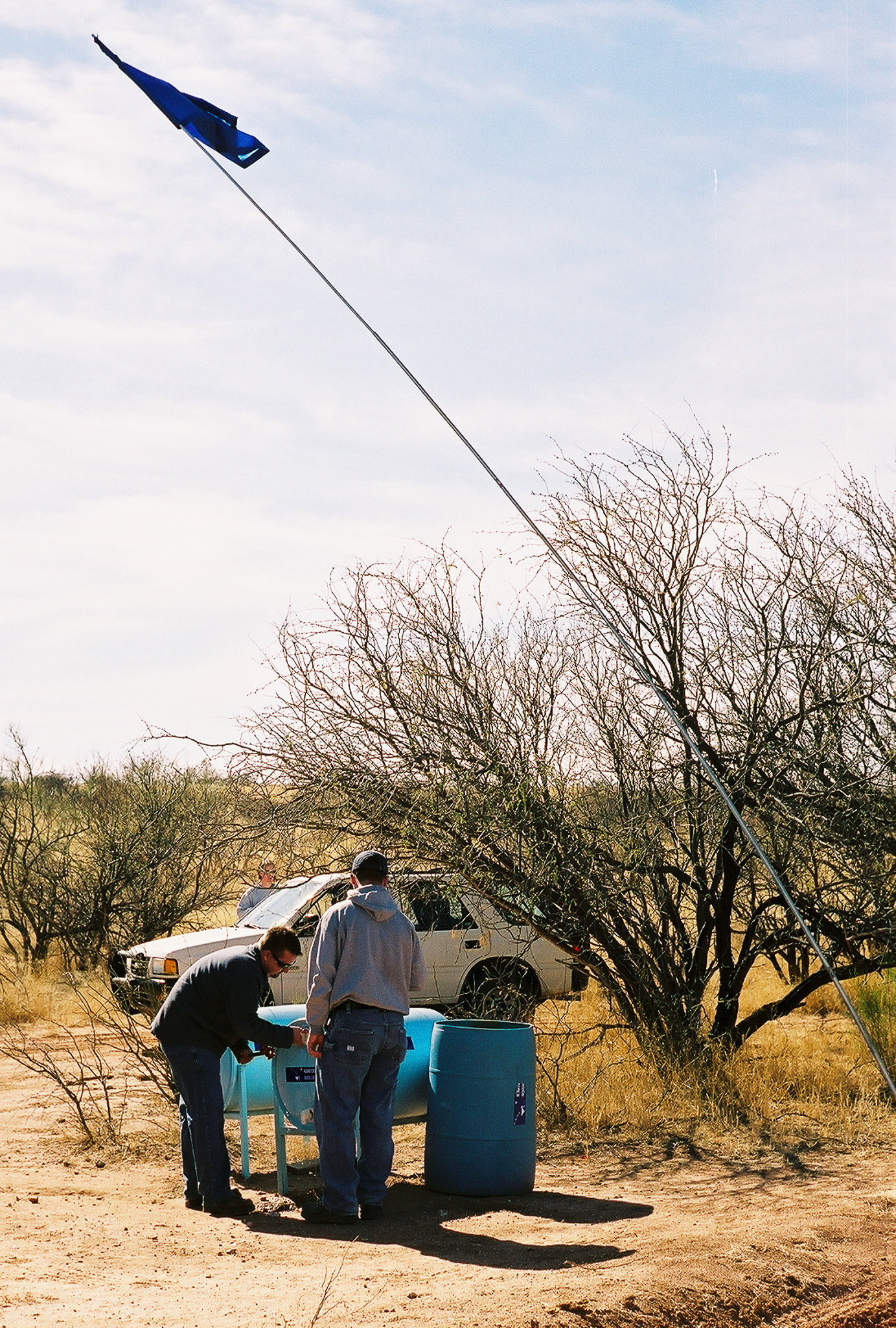 A Humane Borders aid station in the Sonoran desert south of Tucson, AZ. The blue flag signals to migrants that fresh water is available if they are in trouble. Most migrants avoid the stations, fearing border patrol monitoring. Yet, in desperate cases of dehydration these stations ultimately save lives.