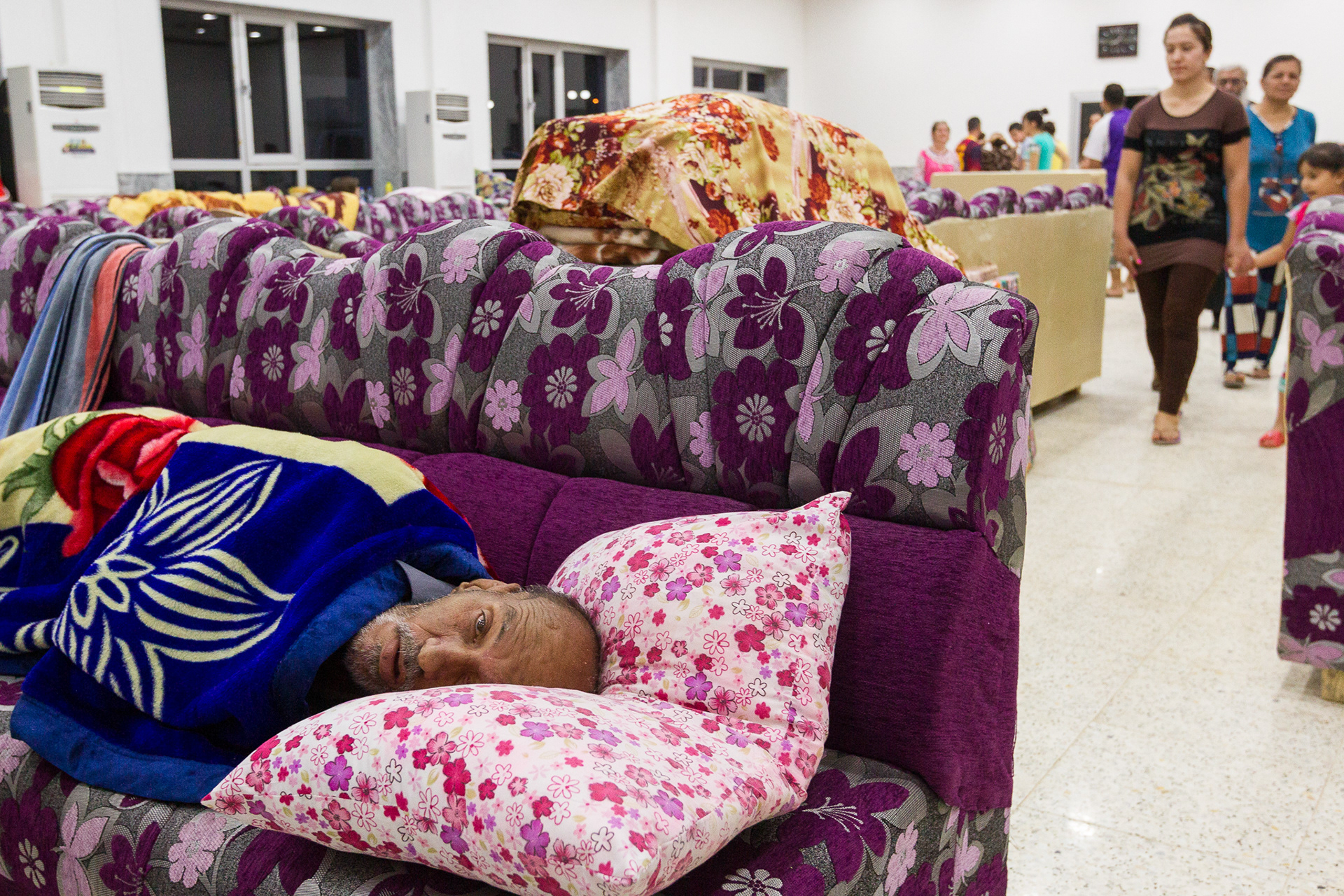 A disabled man rests in the makeshift dormitory set up in the fellowship hall of St. Peter and Paul Ancient Assyrian Church of the East in Dohuk, Iraq. He was transported from Qaraqosh on the Nineveh plain south of Mosul as ISIS forces advanced.