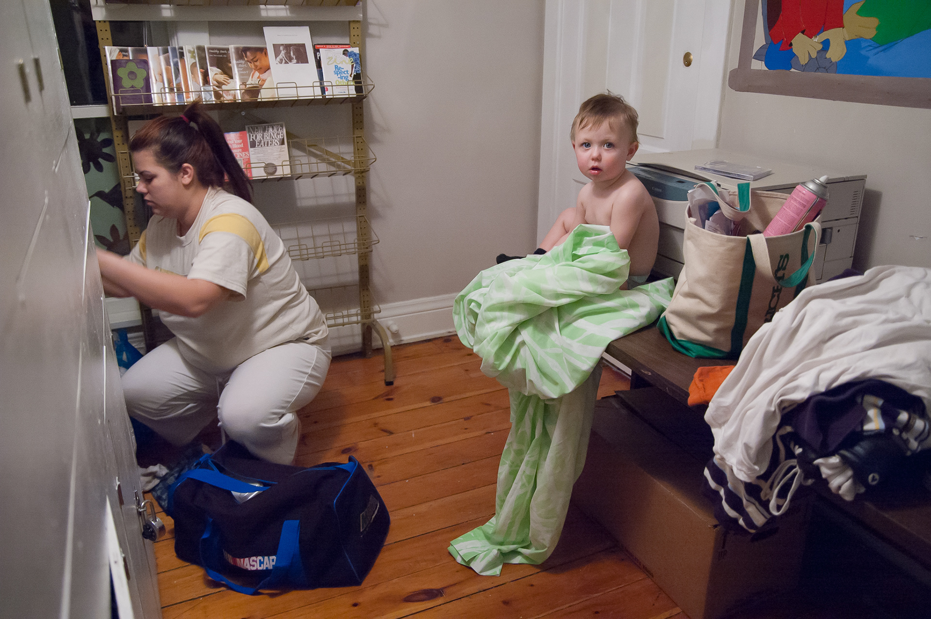 New arrivals to IHNWC, Alycia Doughman and Zachary, rummage through their storage locker in the early morning hours. During their time in the program this small cubicle will store all their possessions.