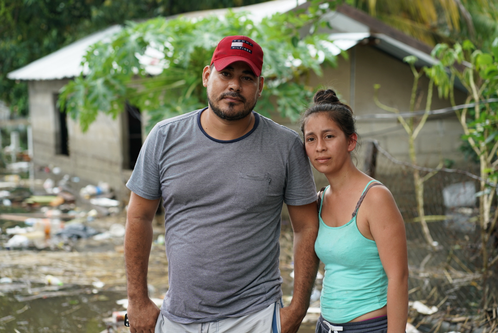 Andony Albaraldo Leiba and his wife Doris Marleny Zubiga stand in front of their flooded home in the Los Castanos neighborhood of Choloma, Honduras.