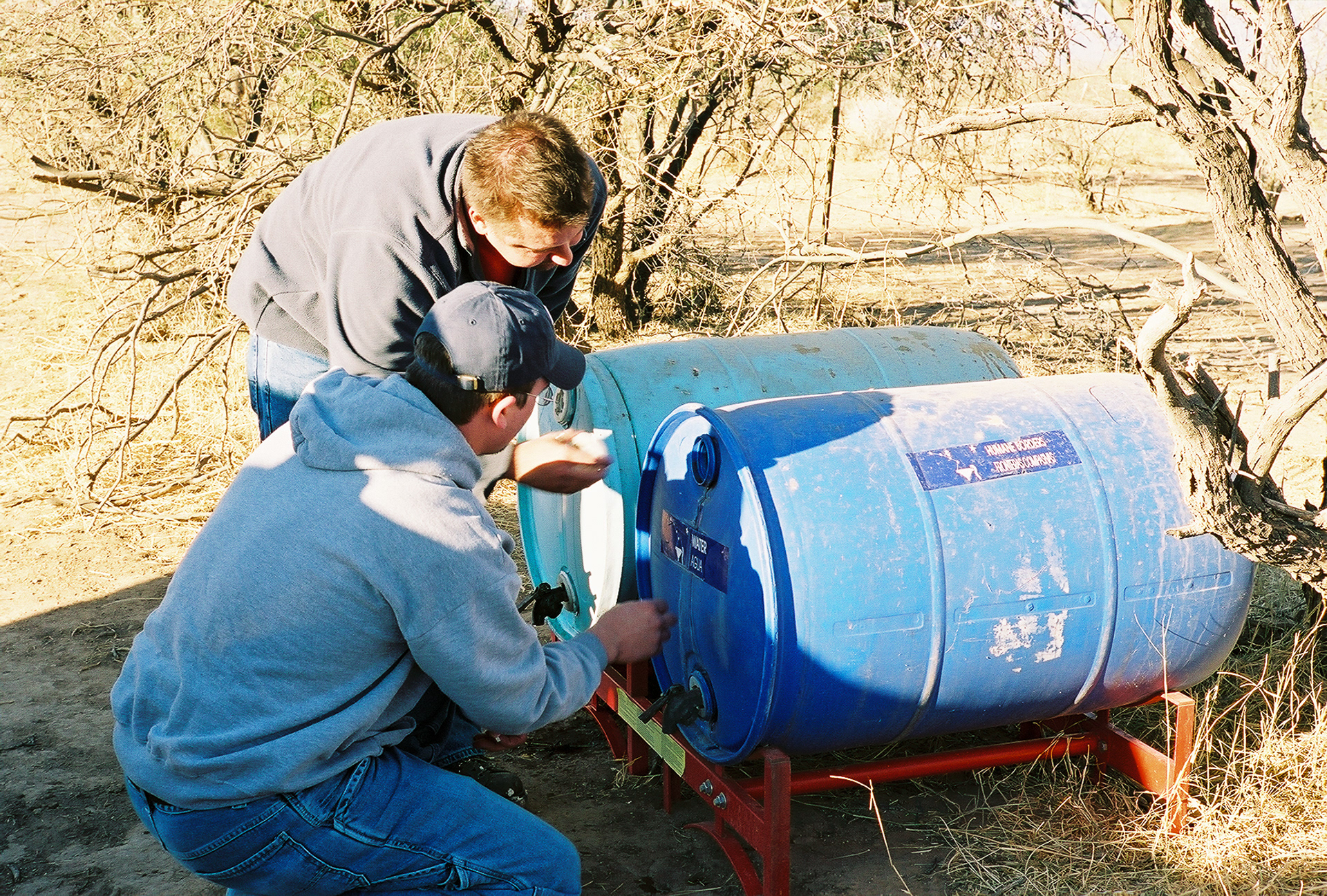 T.K. Estes (Tucson) and John Virgin check the water level in one of Humane Border's fresh water emergency stations in the Sonoran desert south of Tucson, AZ.