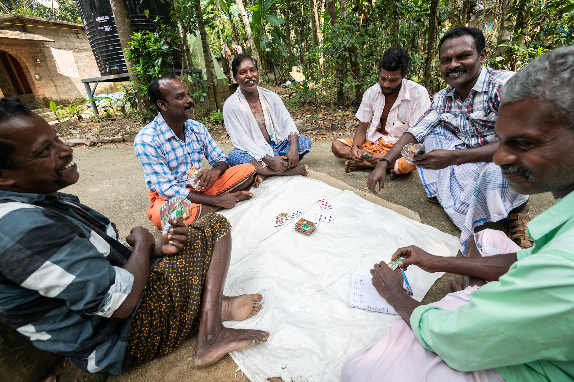 Men take a Sunday afternoon break to play cards in Kurichimuttom, the largest Dalit colony in Kerala, India.