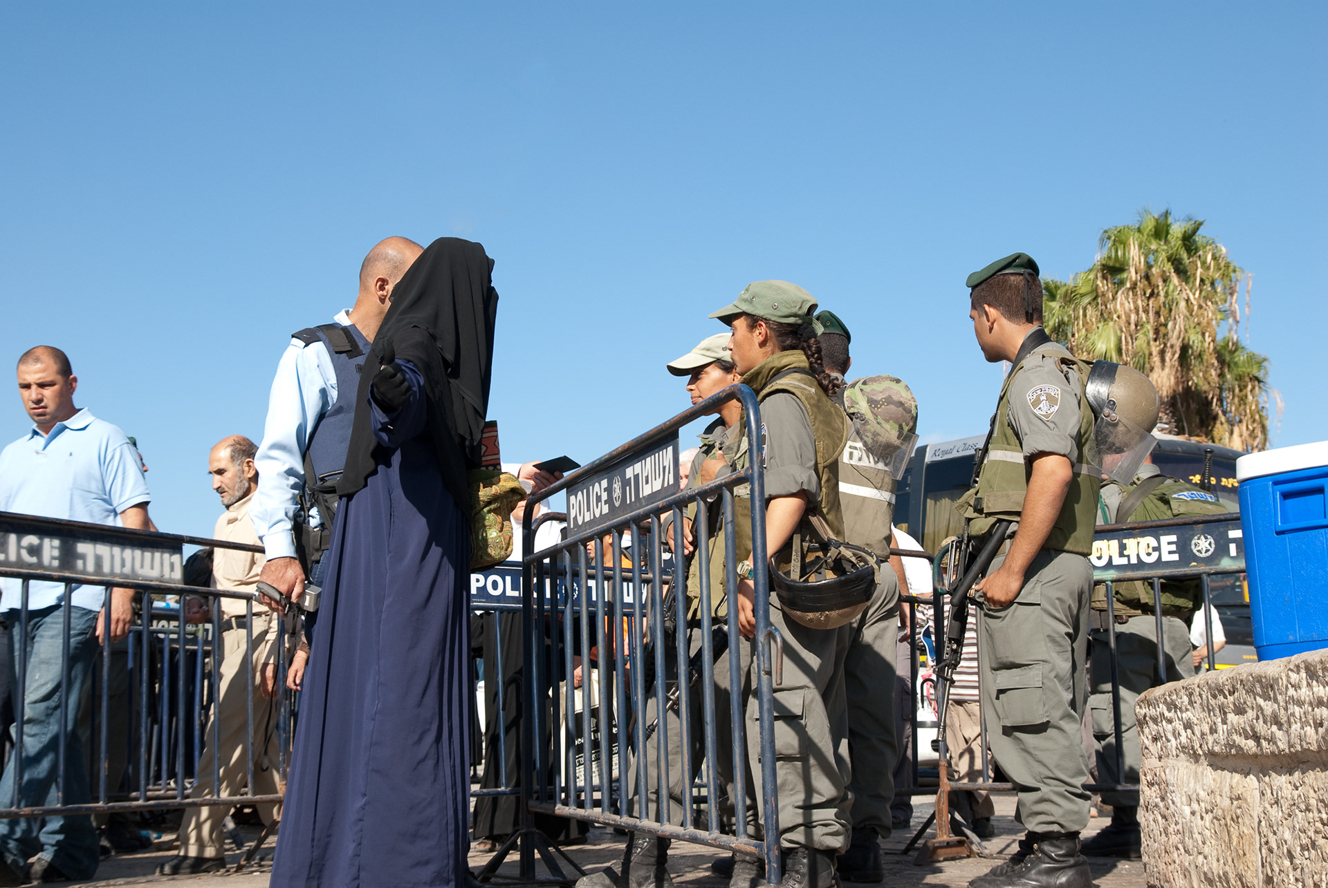 A Palestinian woman in full hijab is prevented from entering the Old City of Jerusalem due to increased tensions during Ramadan.