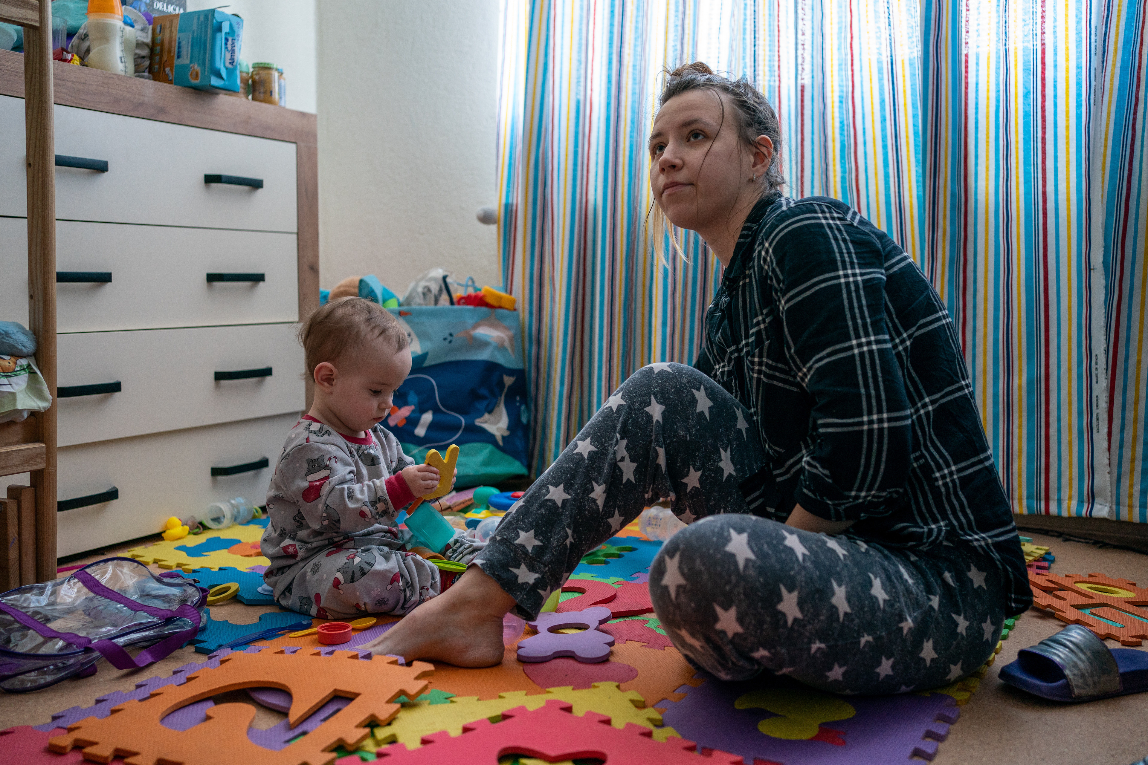 Dasha Habovska plays with her son, Christian, in their room at the St. Martin Center in Fastiv, Ukraine, with seven other families.