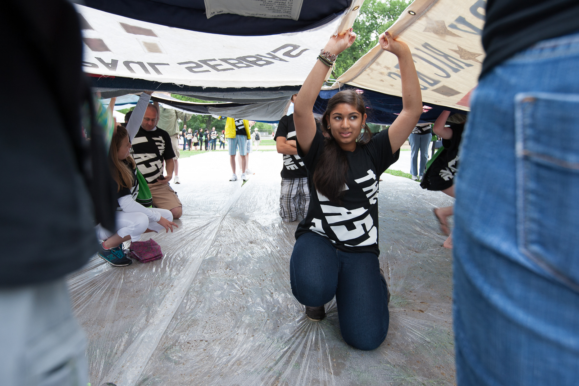 Volunteers were needed beneath large sections of the AIDS Quilt to support it at an unveiling ceremony July 21, 2012, as part of the International AIDS Conference.