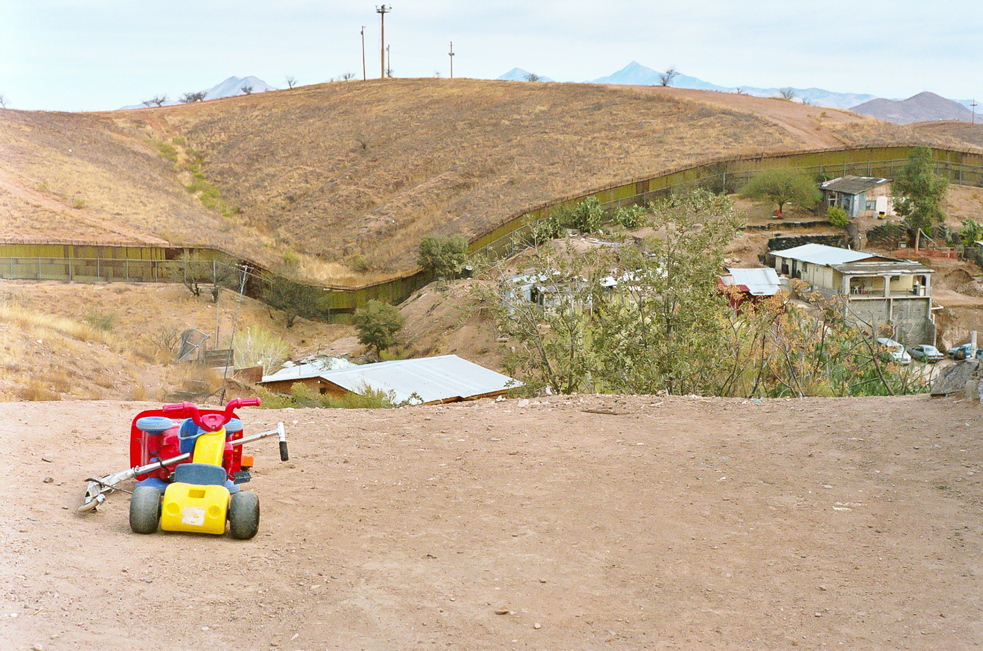 Children's toys on the Mexican hillside looking toward the US. Houses abut the fence in this "invasion community." In addition to the fence infrared cameras monitor human traffic 24/7 along this stretch of the border.