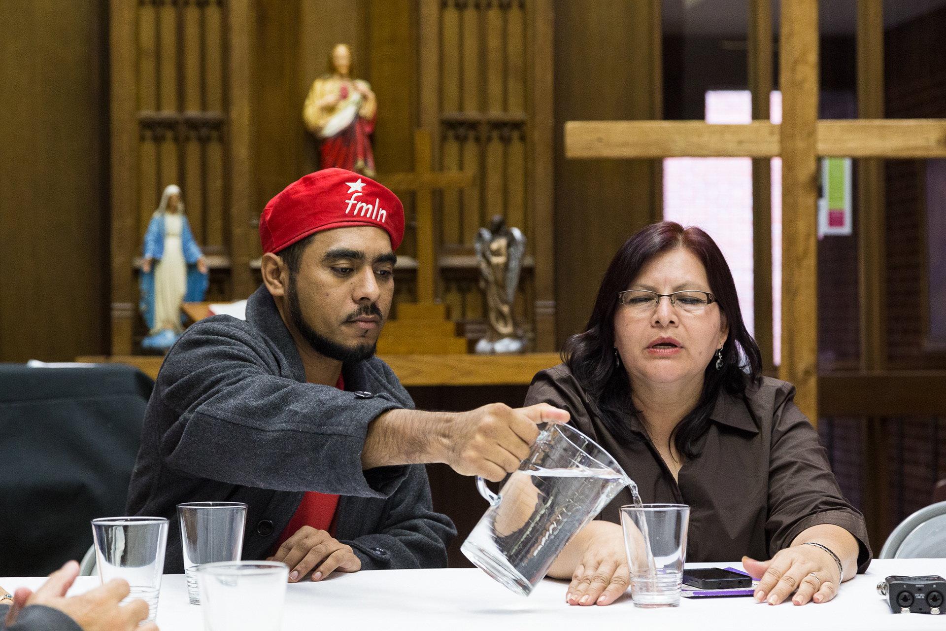 Portland Sanctuary seeker, Francisco Aguirre, pours water for Salvadoran Congresswoman Emma Julia Fabian Hernandez during her 20 October 2014 visit.