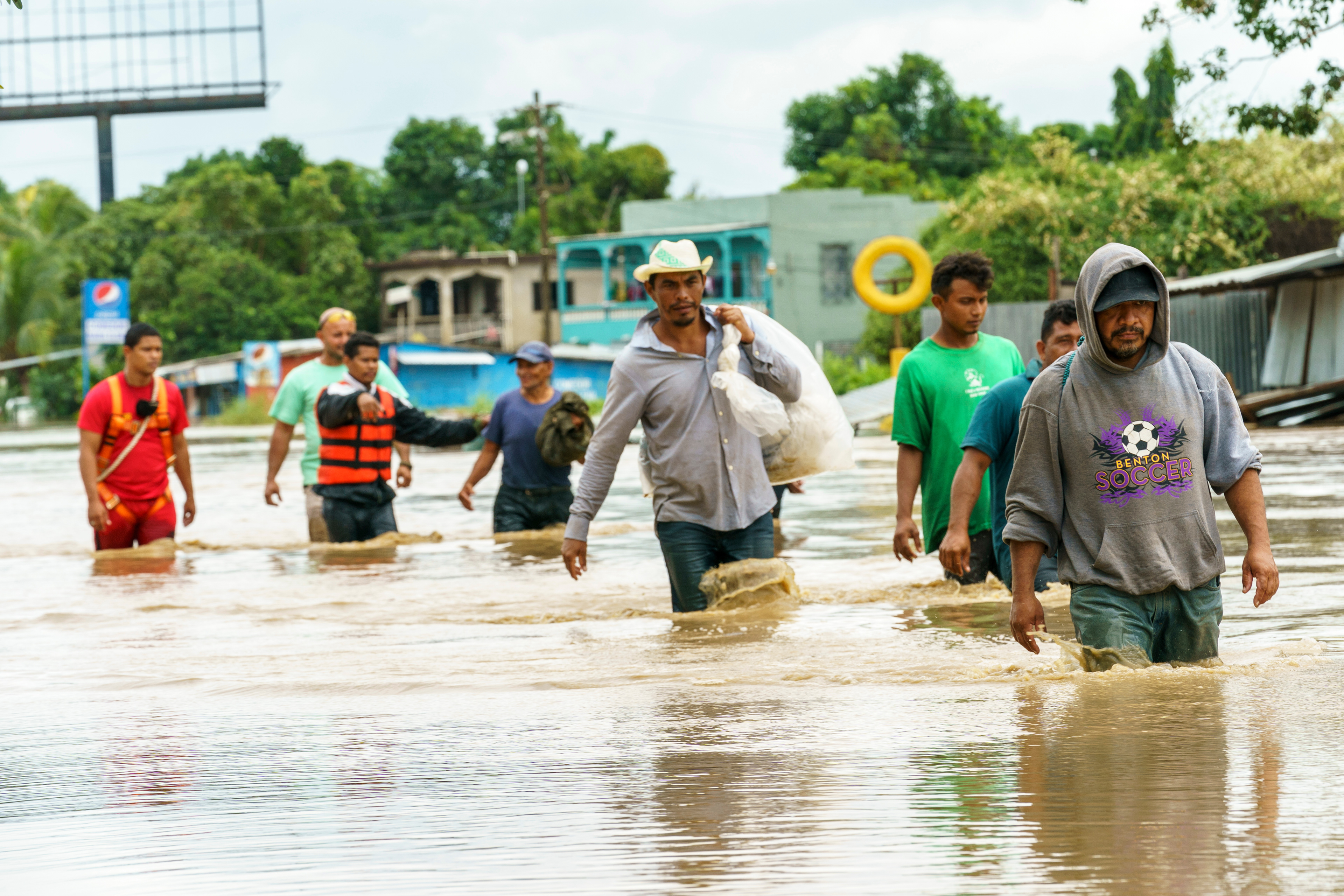 Fire crews help evacuees through rushing water in Jerusalen, Honduras, following Hurricane Iota. Only two weeks prior, Hurricane Eta saturated this low lying area in the northwest of the country.