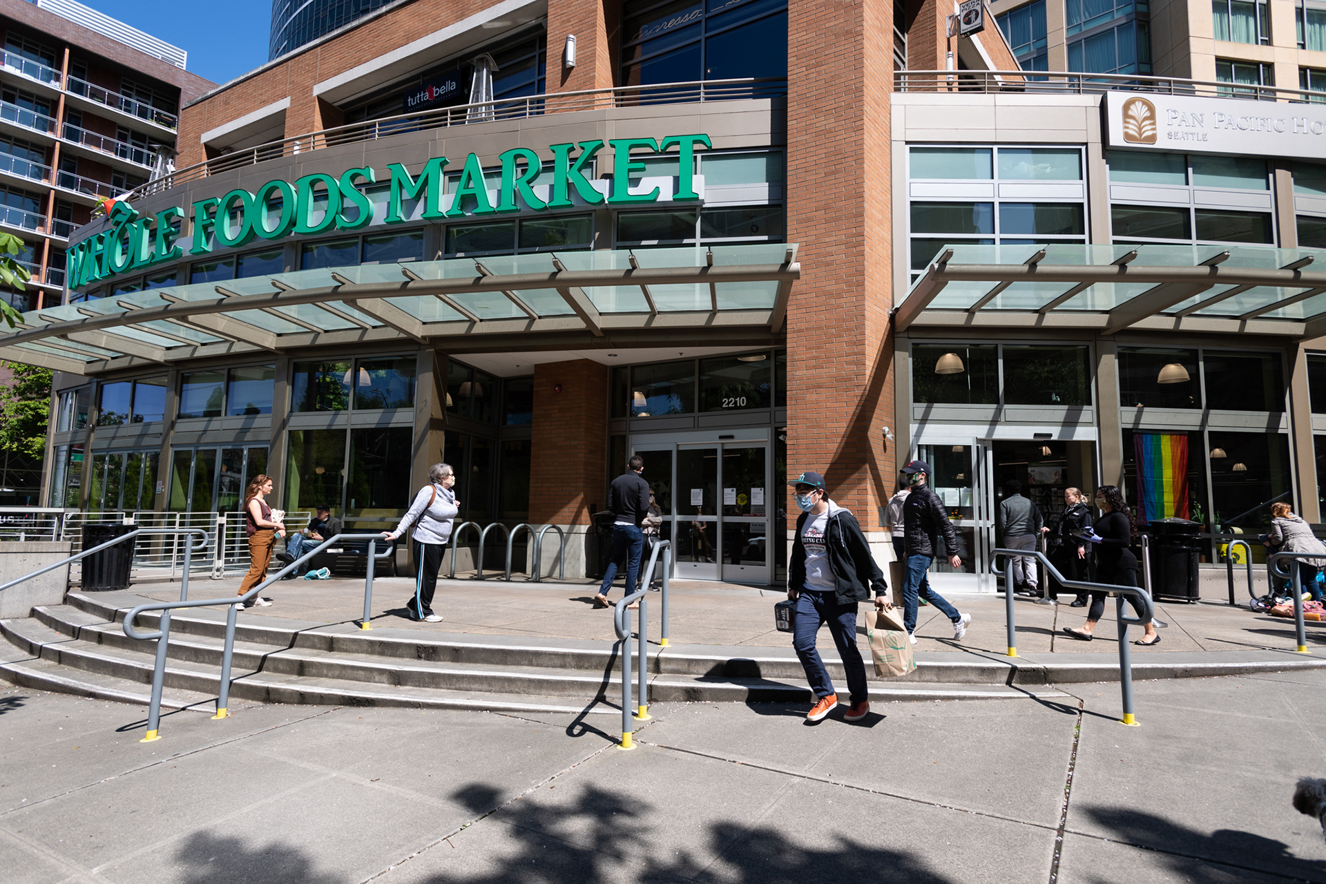 Customers wait in queue at Whole Foods to limit the number of customers in the store in downtown Seattle.